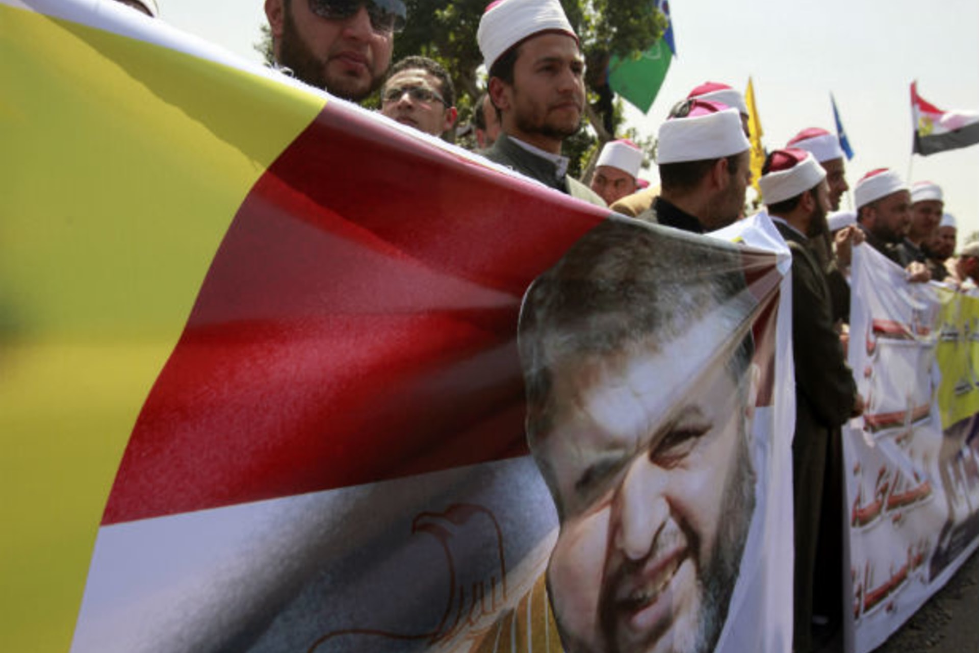 Supporters of presidential candidate from the Muslim Brotherhood and the Freedom and Justice Party Khairat al-Shater, cheer while carrying banners bearing images of him, as he presents recommendation documents to the Higher Presidential Electio