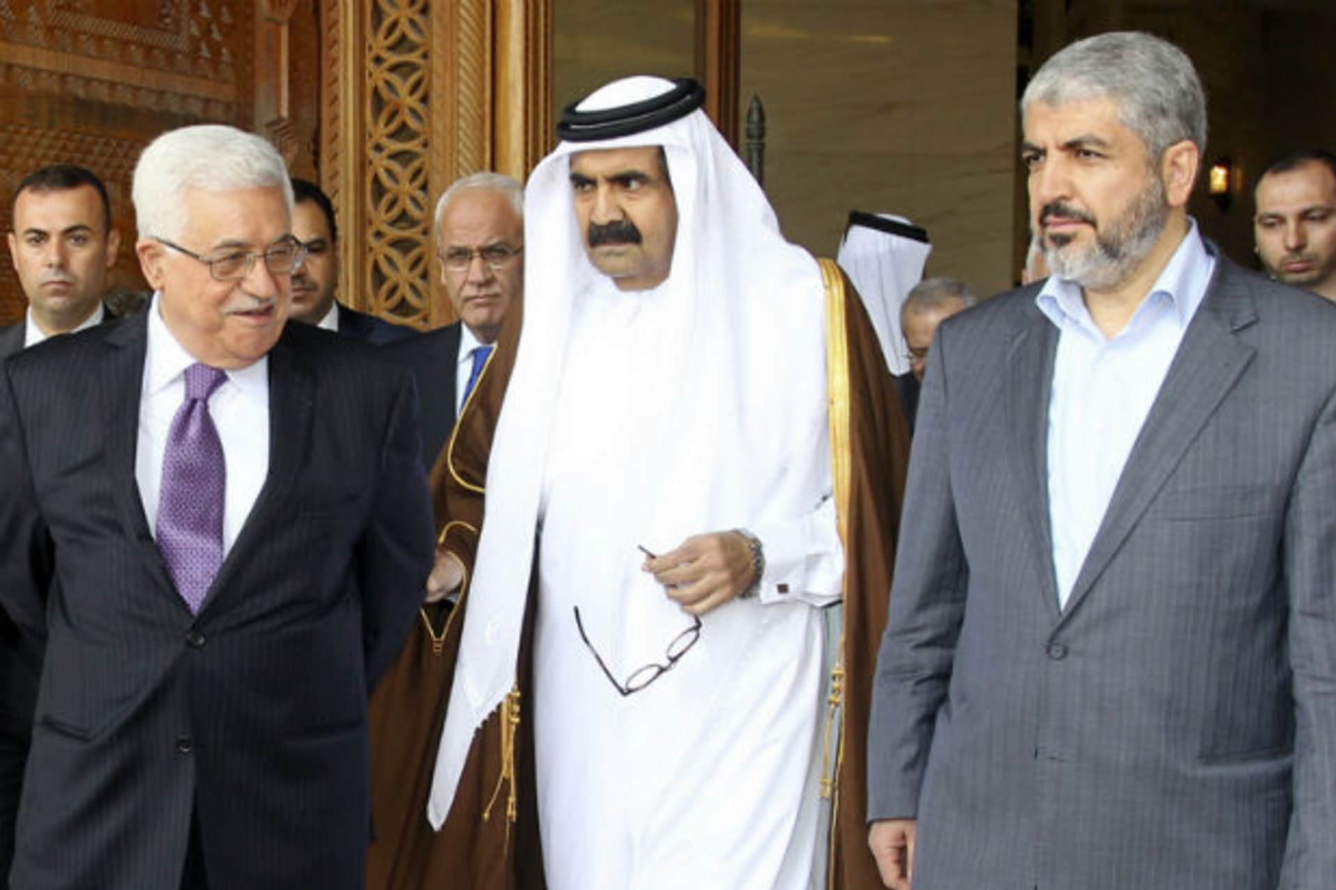 Palestinian president Mahmoud Abbas and Hamas leader Khaled Meshaal walk with Qatar's emir sheikh Hamad bin Khalifa al-Thani as they arrive to sign an agreement in Doha on February 6, 2012 (Courtesy Reuters).