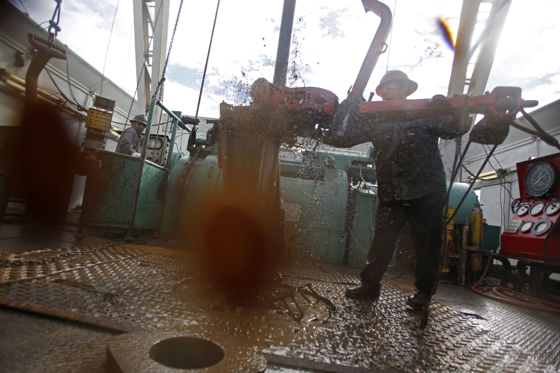 Roughnecks wrestle pipe on a True Company oil drilling rig outside Watford