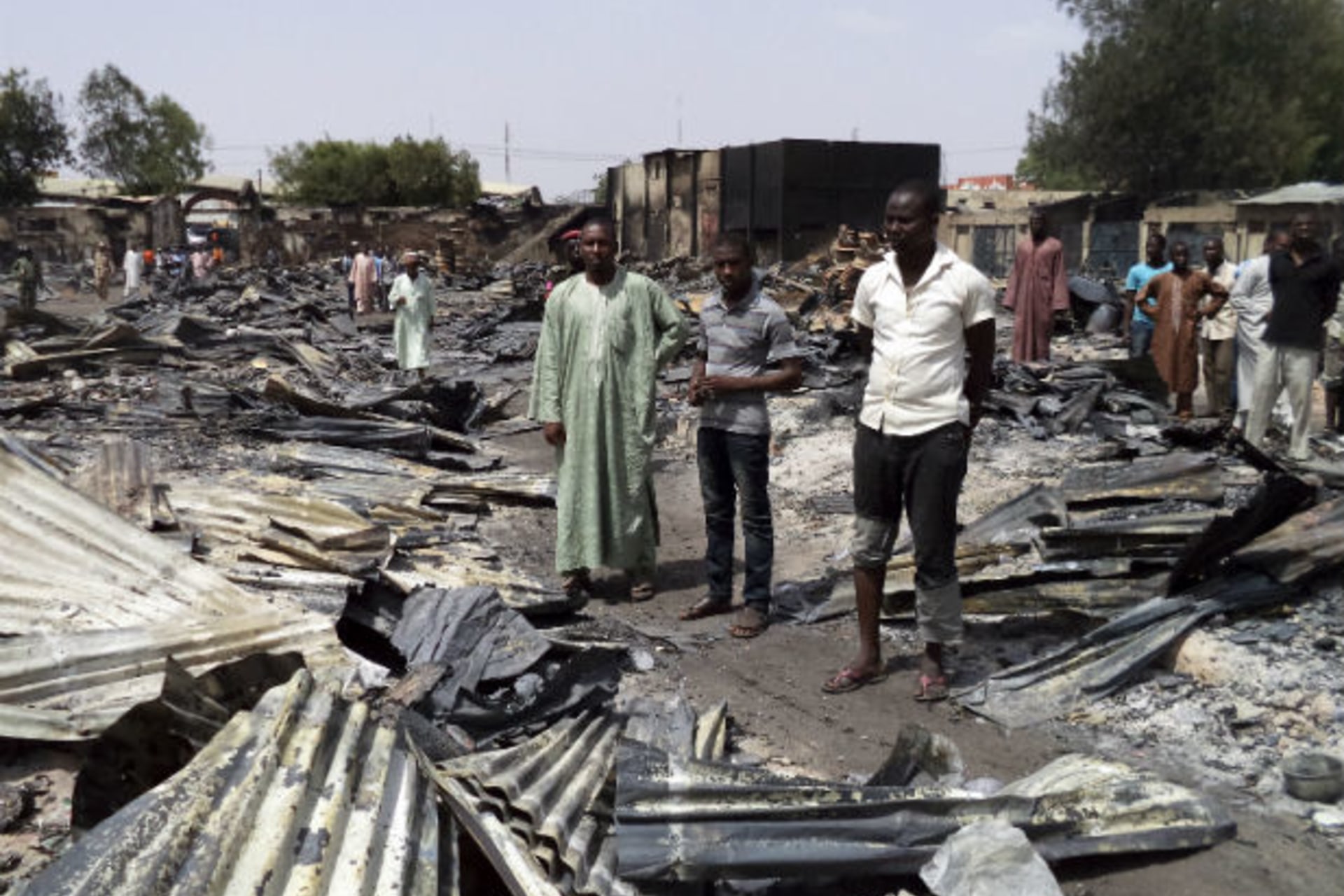 People gather around the ruins of the burnt Bama Market, which was destroyed by gunmen in last Thursday's attack, in Maiduguri, northeast Nigeria April 29, 2013.