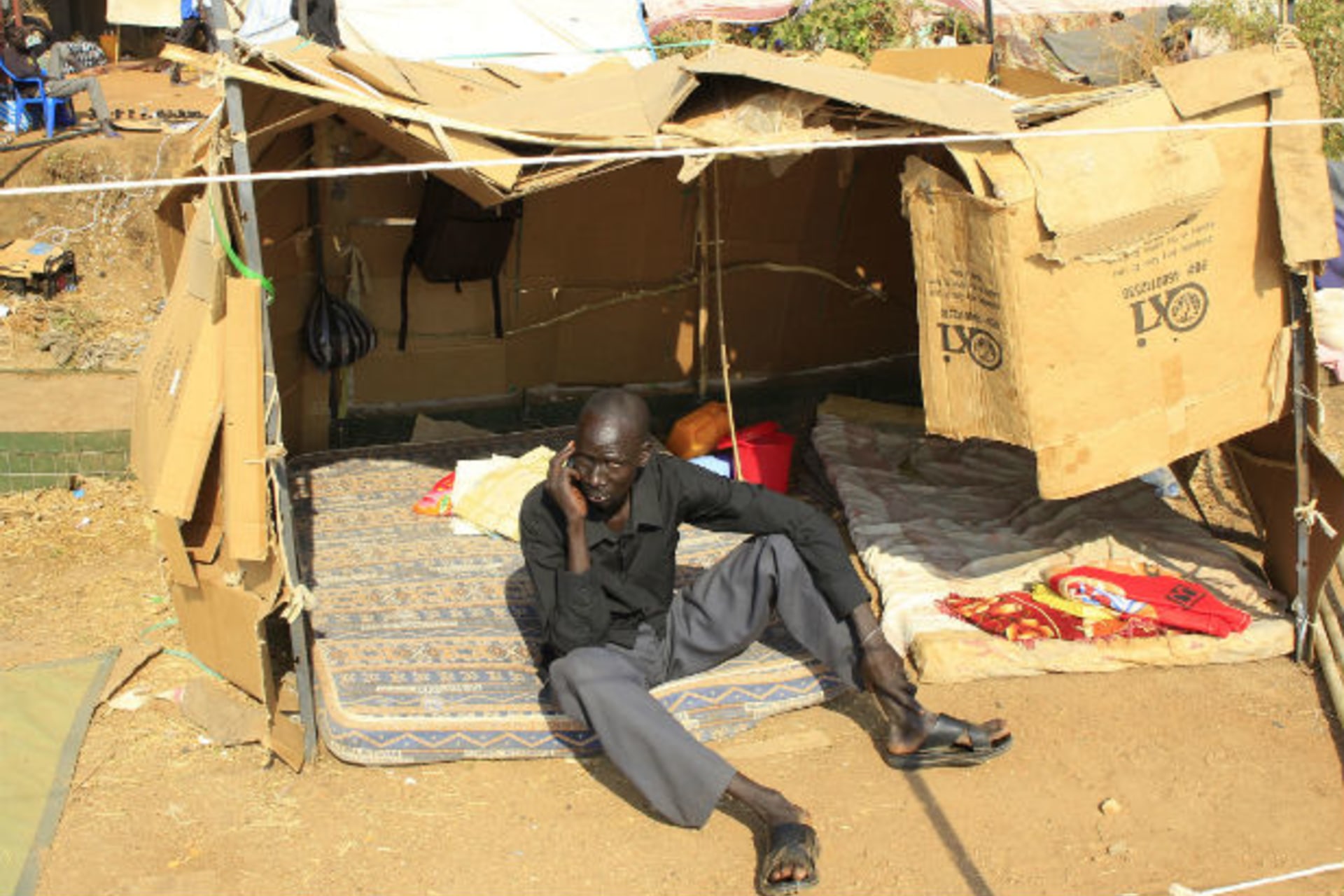 A displaced man speaks on a cellphone in his makeshift shelter at Tomping camp, where some 15,000 displaced people who fled their homes are sheltered by the United Nations, near South Sudan's capital Juba January 7, 2014.