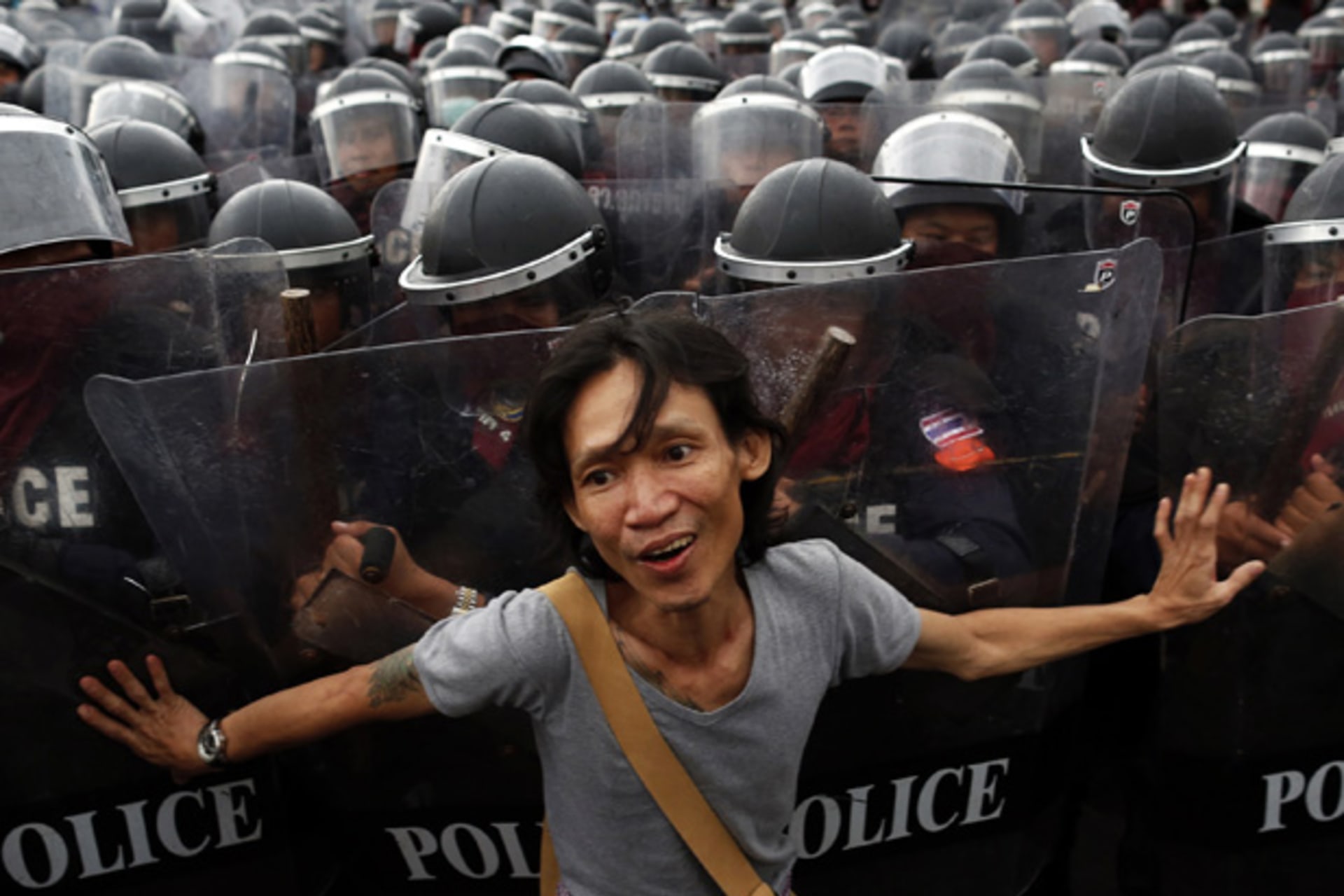 <p>An anti-government protester pushes riot police officers during scuffles near the Government house in Bangkok November 24, 2012.</p>

