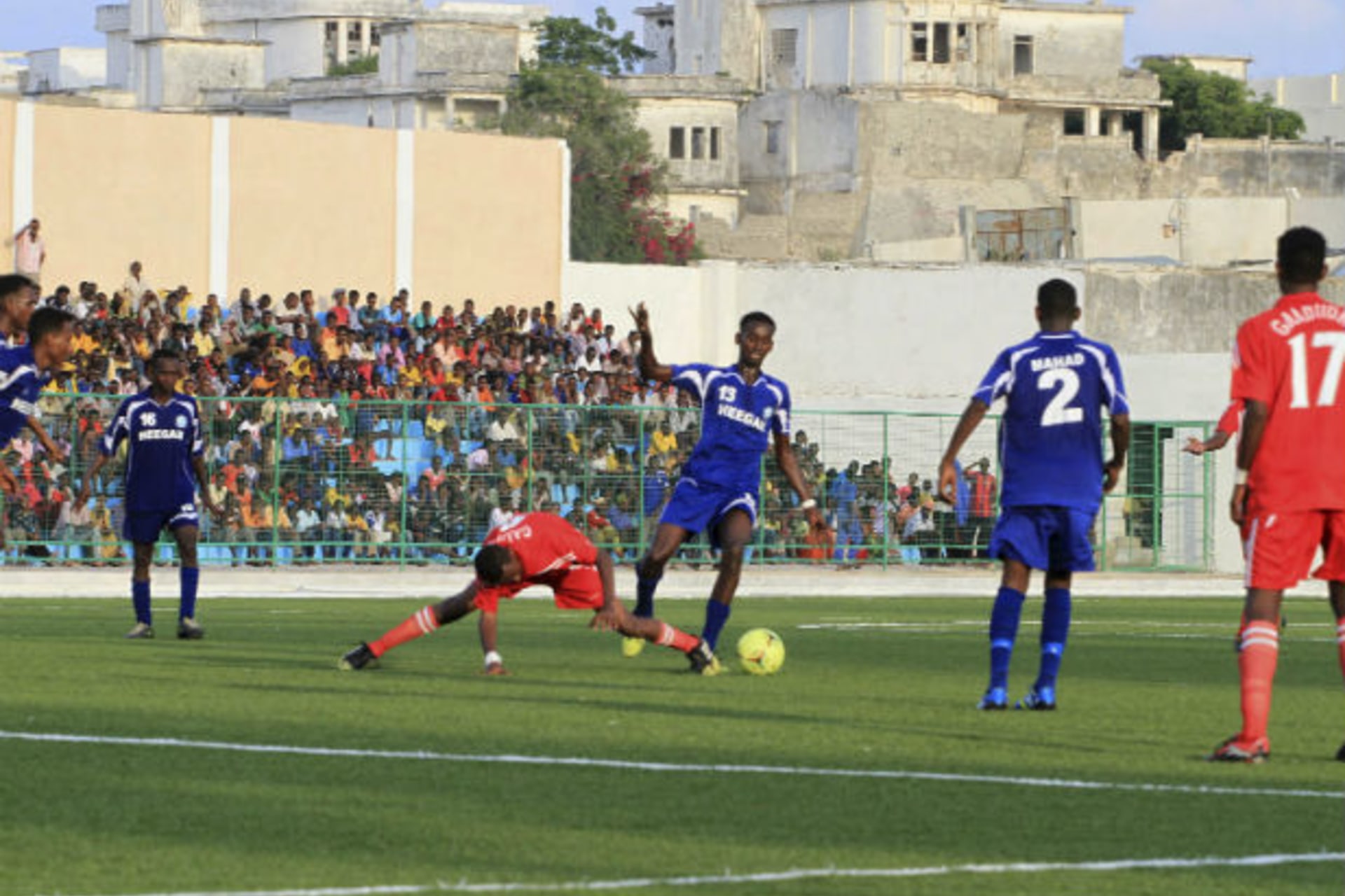 Players from Heegan (blue shirt) compete against players from Gaaddidka (red shirt) during the first soccer match of the Somalia Premier League at the Banadir stadium in Mogadishu November 8, 2013.