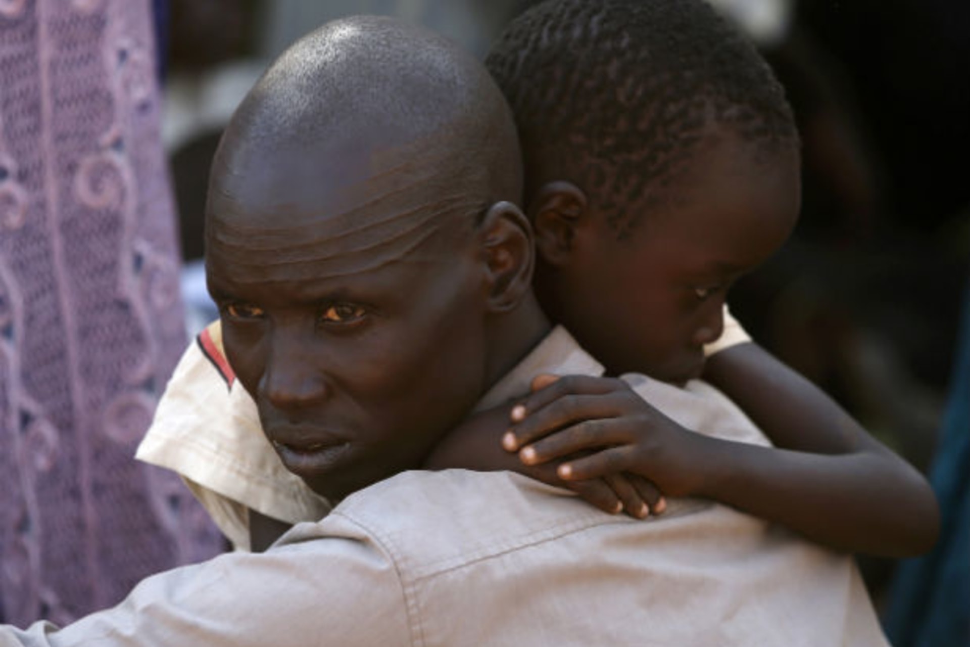 An internally displaced man holds his son inside a United Nations Missions in Sudan (UNMIS) compound in Juba December 19, 2013.