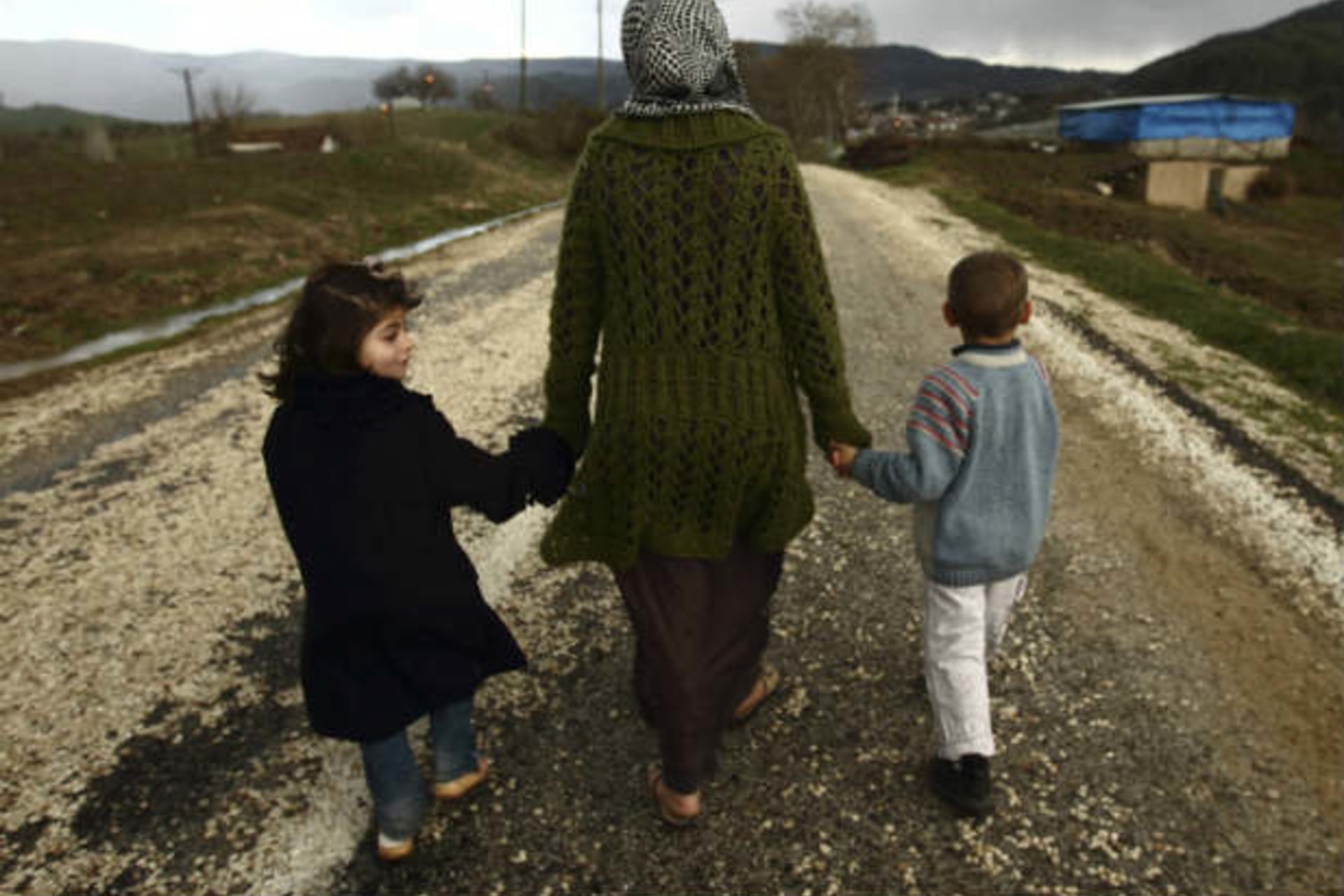 Sawssan Abdelwahab, who fled Idlib in Syria, walks with her children outside the refugees camp near the Turkish-Syrian border in the southeastern city of Yayladagi (Bensemra/Courtesy Reuters).