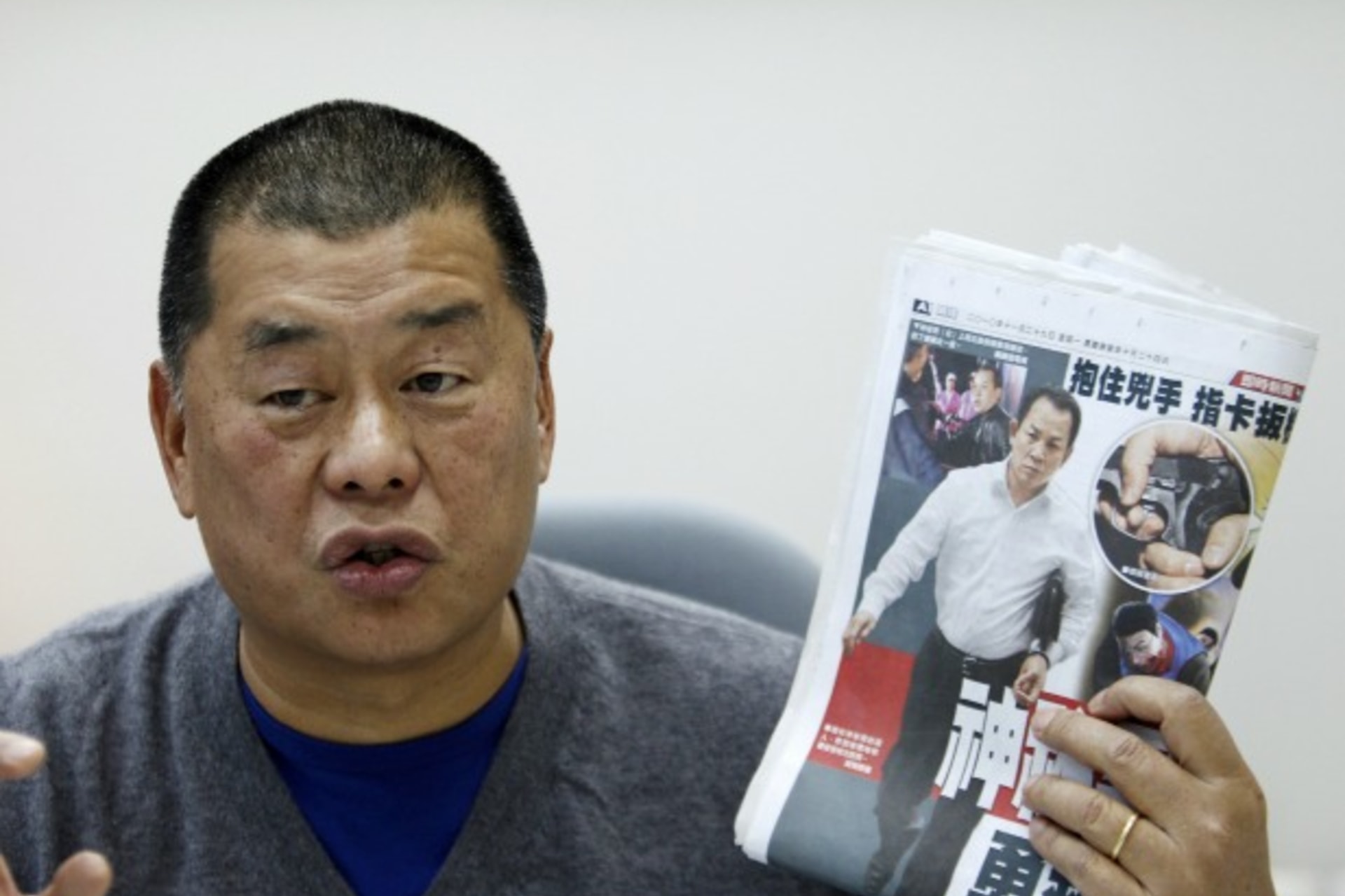 <p>Jimmy Lai, chairman and founder of Next Media, holds up a copy of the Apple Daily newspaper as he speaks to Reuters in Taipei on November 29, 2010.</p>
