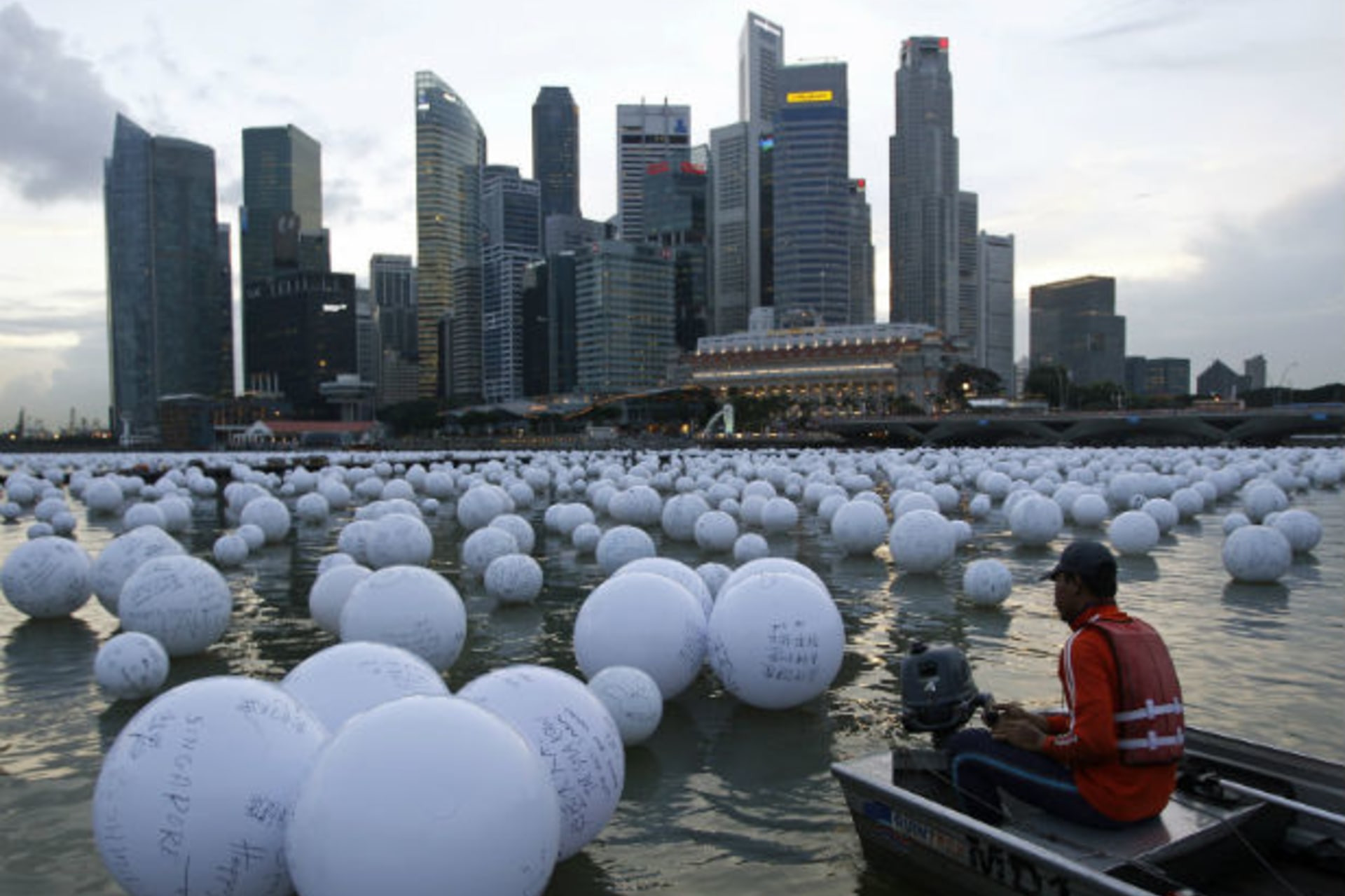 A boatman arranges wishing spheres released onto the Singapore River as part of New Year Day celebrations. (Edgar Su/Courtesy Reuters)