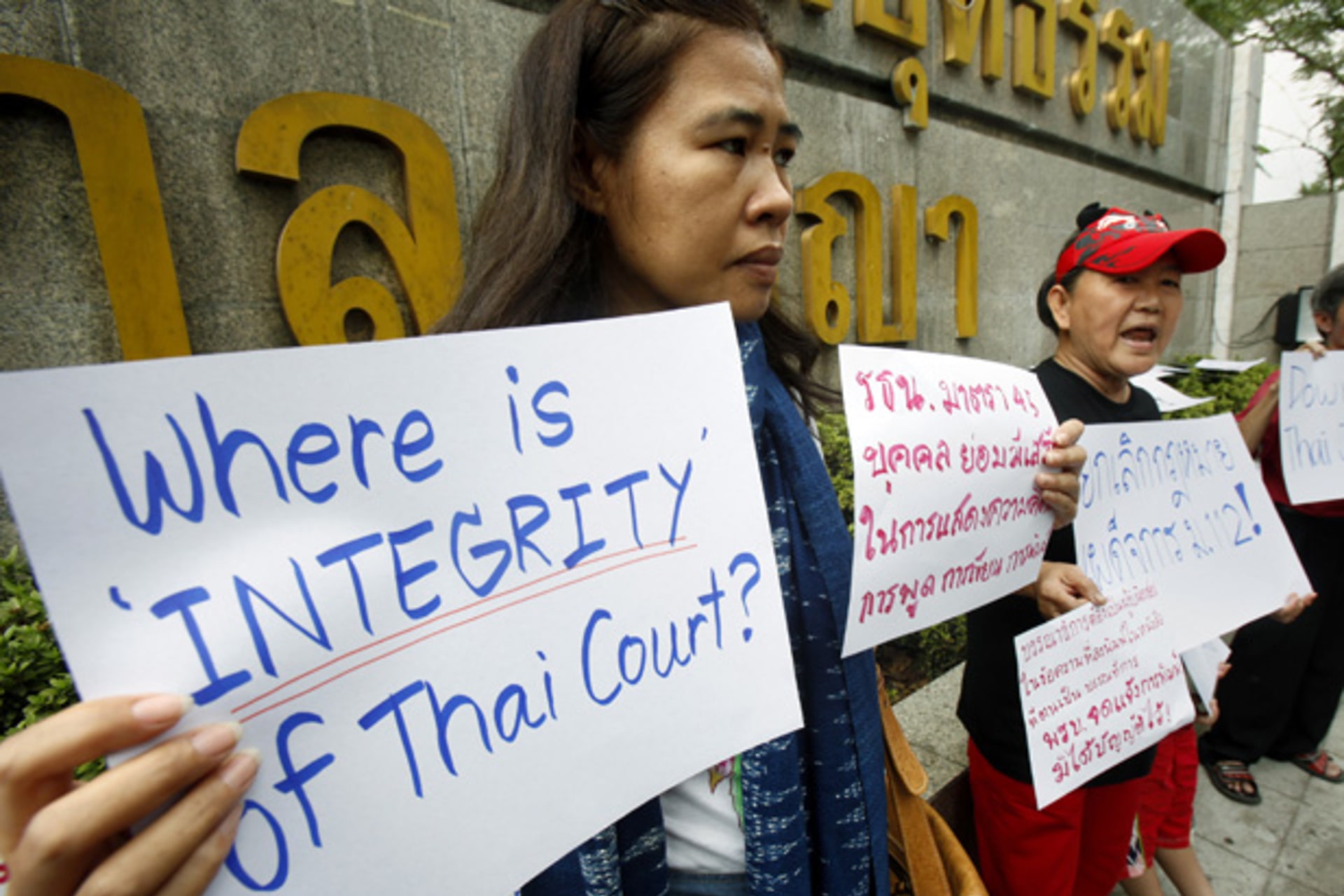 <p>Activists hold signs as they gather in front of the Thai Criminal court during a protest in Bangkok January 25, 2013.</p>