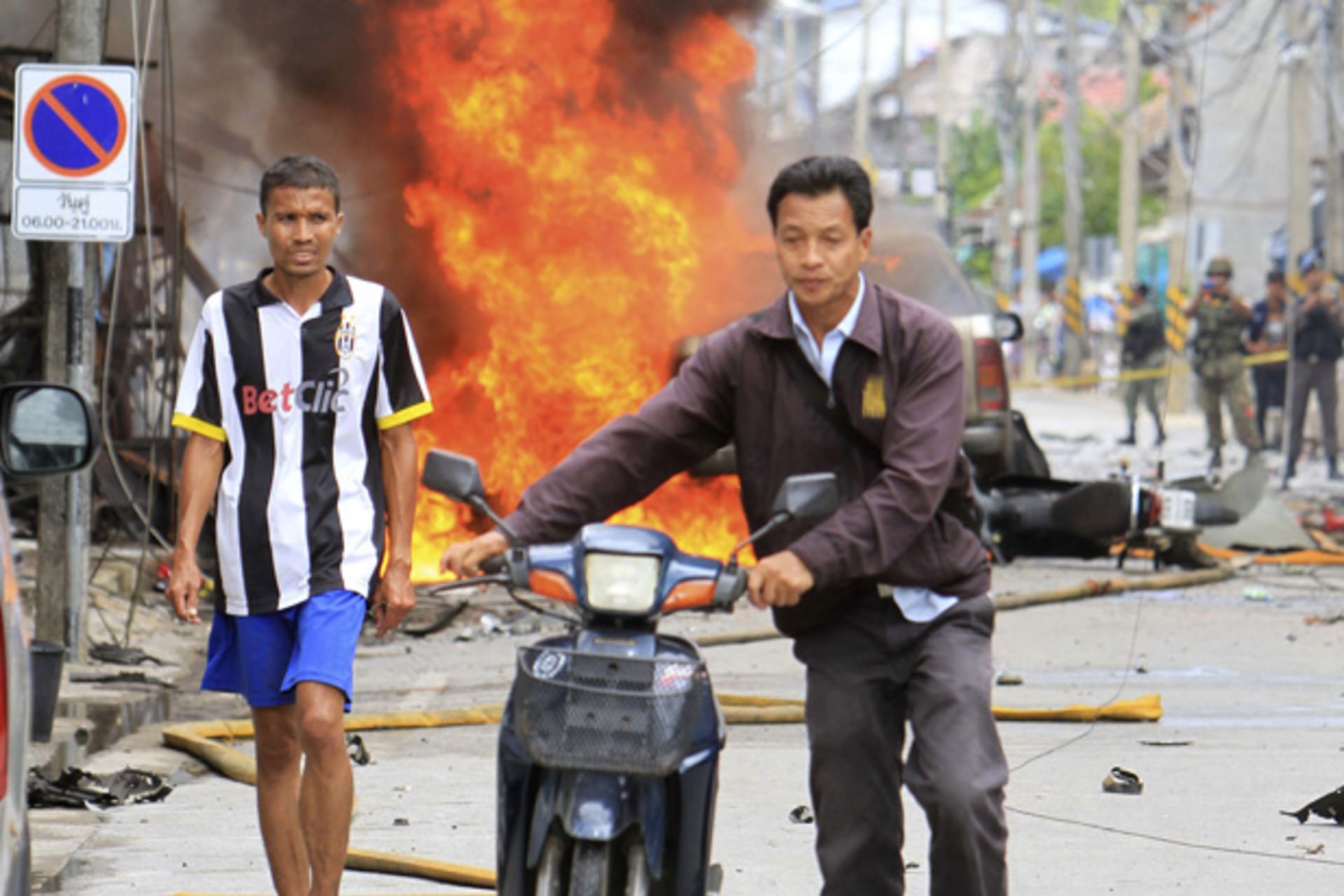 <p>People leave the scene after a car bomb exploded in southern Thailand’s Sai Buri district.</p>
