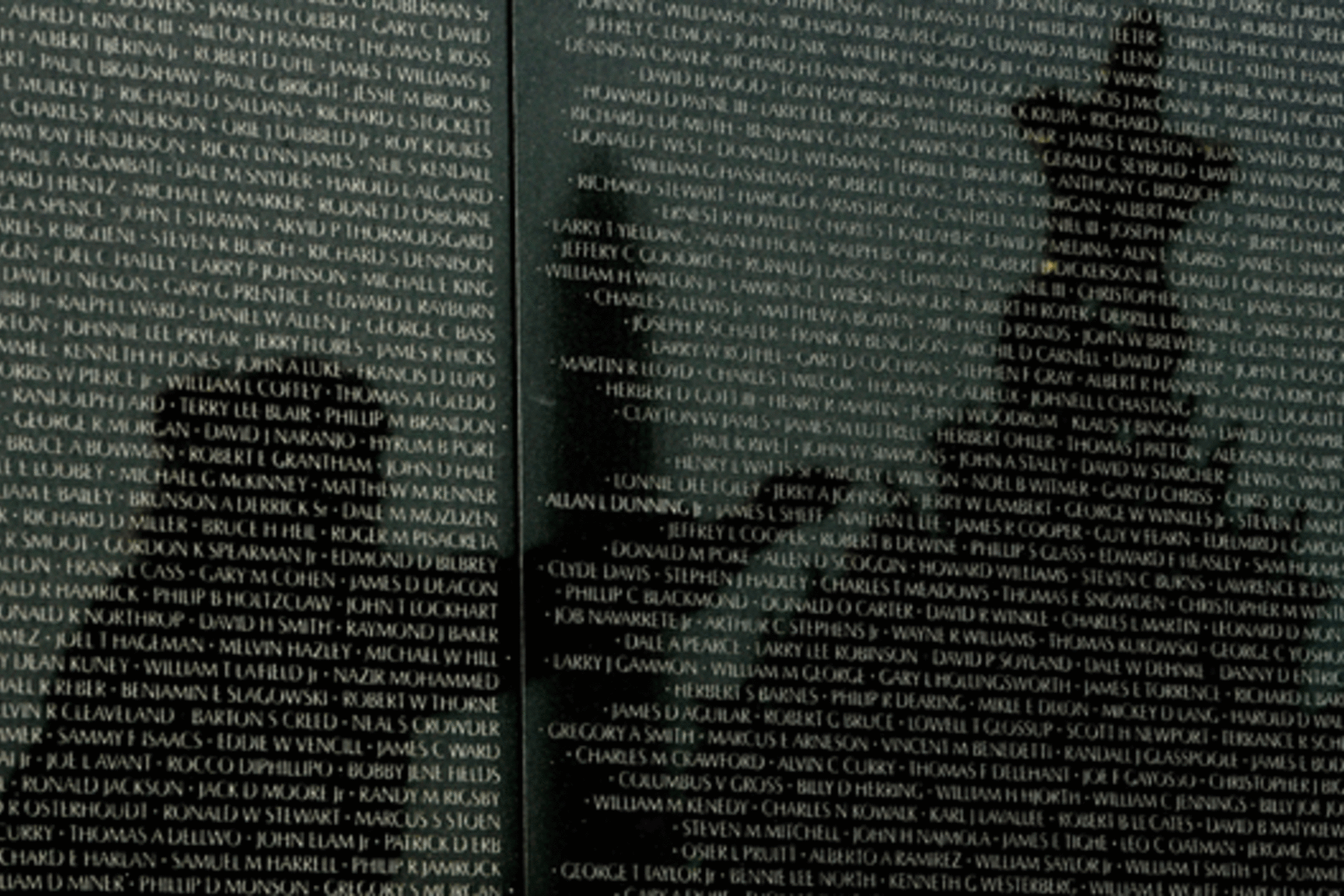<p>Reflected on the wall listing in the names of American soldiers who died in the Vietnam War, a veteran helps decorate the Christmas tree placed at the Vietnam War Memorial in Washington on December 23, 2008. (Kevin Lamarque/courtesy Reuters)</p>
