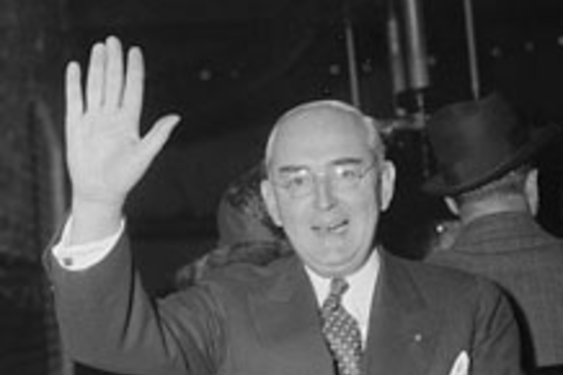 <p>Senator Arthur H. Vandenberg salutes the camera man as he uses the tram for the trip from the Senate Office building to Capitol. (Harris & Ewing/courtesy Library of Congress)</p>
