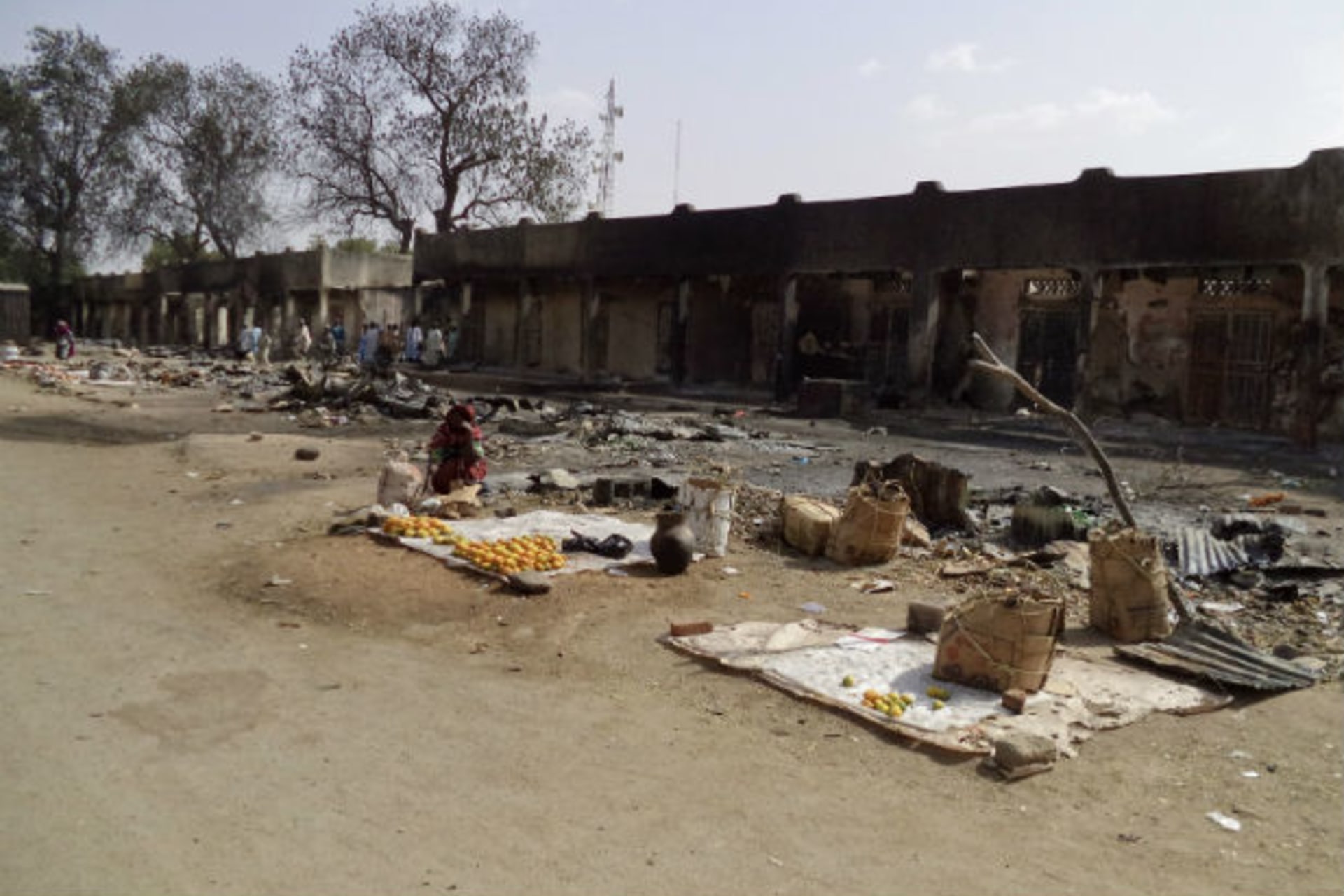 A woman sits amongst the burnt ruins of the Bama Market, which was destroyed by gunmen in last Thursday's attack, in Maiduguri, northeast Nigeria April 29, 2013.