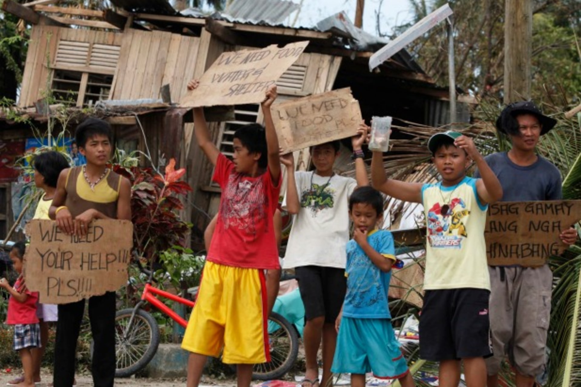 <p>Children hold signs asking for help and food along the highway, after Typhoon Haiyan hit Tabogon town in Cebu Province, central Philippines on November 11, 2013 (Charlie Saceda/Courtesy Reuters).</p>
