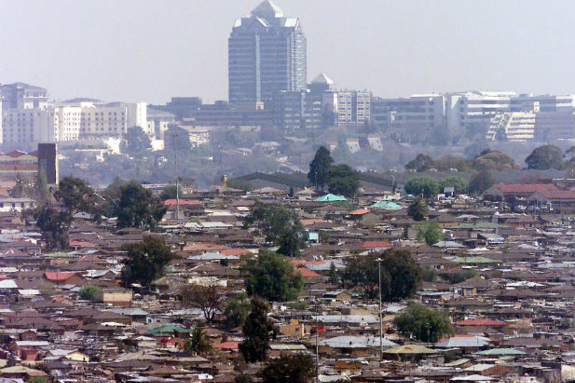 General view of Alexandra township, commonly known as Alex, a slum overlooking the Sandton sky scrappers in Johannesburg August 23, 2002.