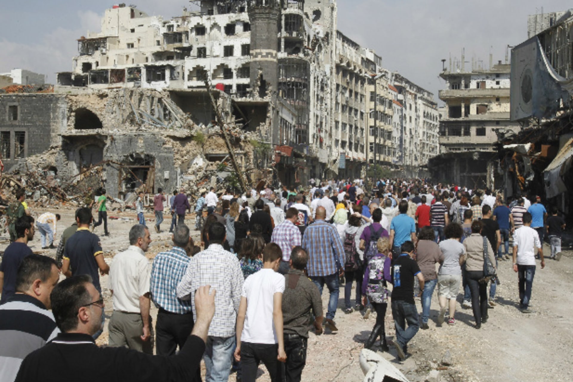 Residents arrive on foot to inspect their homes in the al-Hamdeya neighborhood, after the cessation of fighting between rebels and forces loyal to Syria's president Bashar al-Assad, in Homs May 9, 2014 (al-Hariri/Courtesy Reuters).