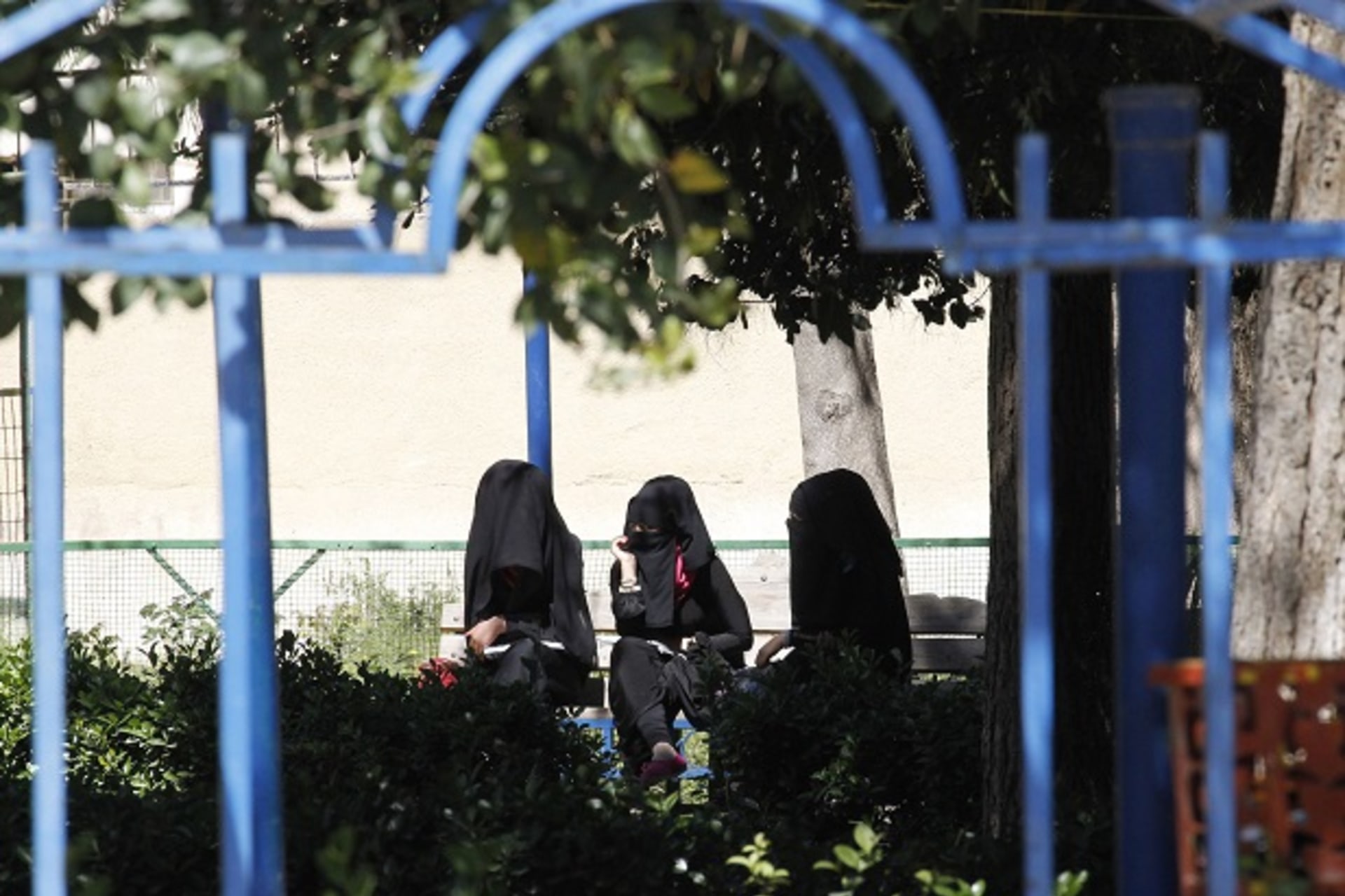 Veiled women sit on a bench in the northern province of Raqqa