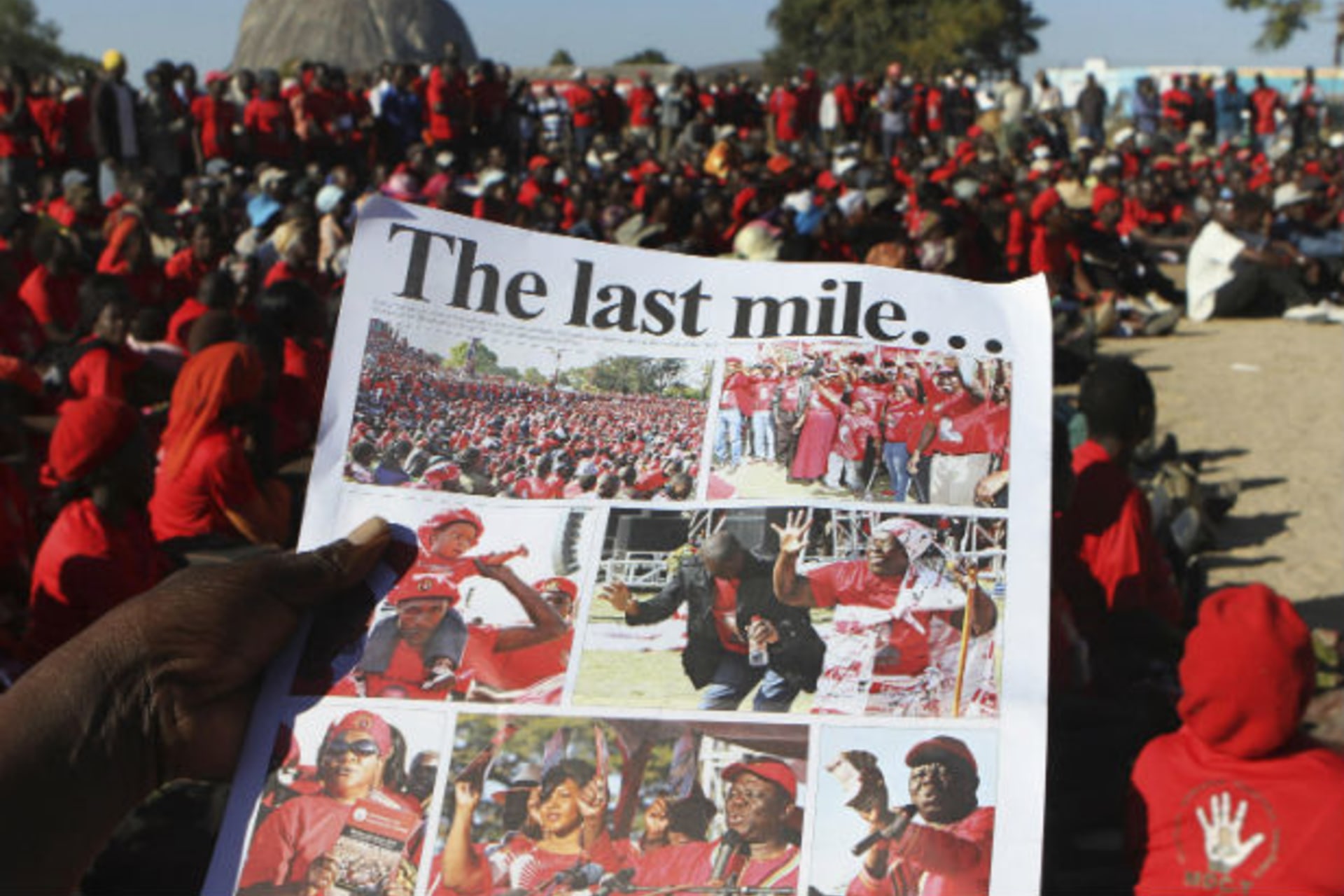 A Zimbabwean opposition party Movement For Democratic Change (MDC) supporter holds a party newsletter at an election rally, about 90 km (56 miles) east of the capital Harare July 23, 2013.