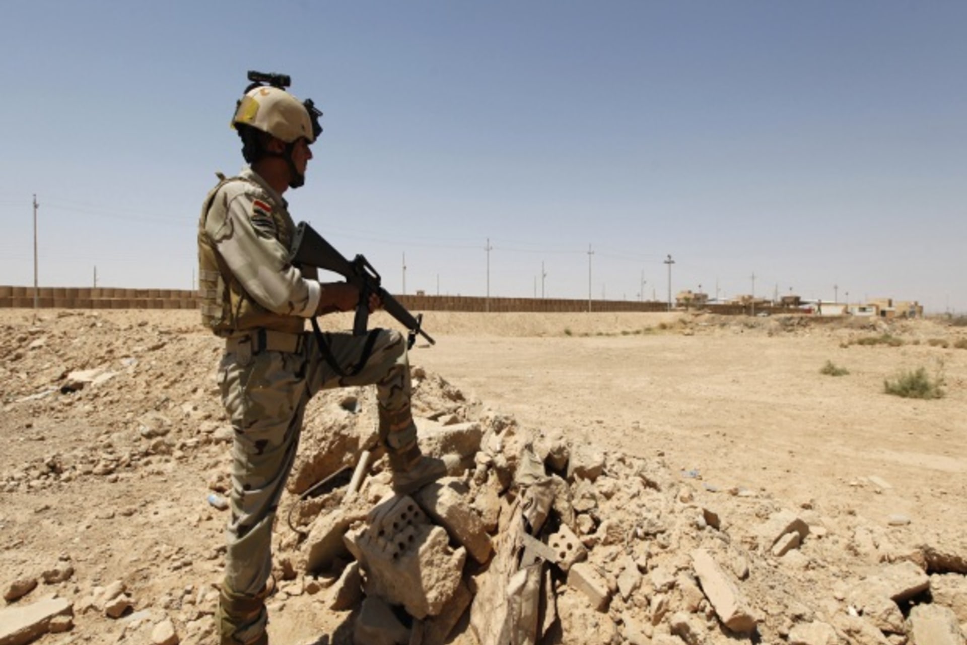 <p>An Iraqi soldier stands guard near the Syrian border (Saad Shalash/Courtesy Reuters).</p>