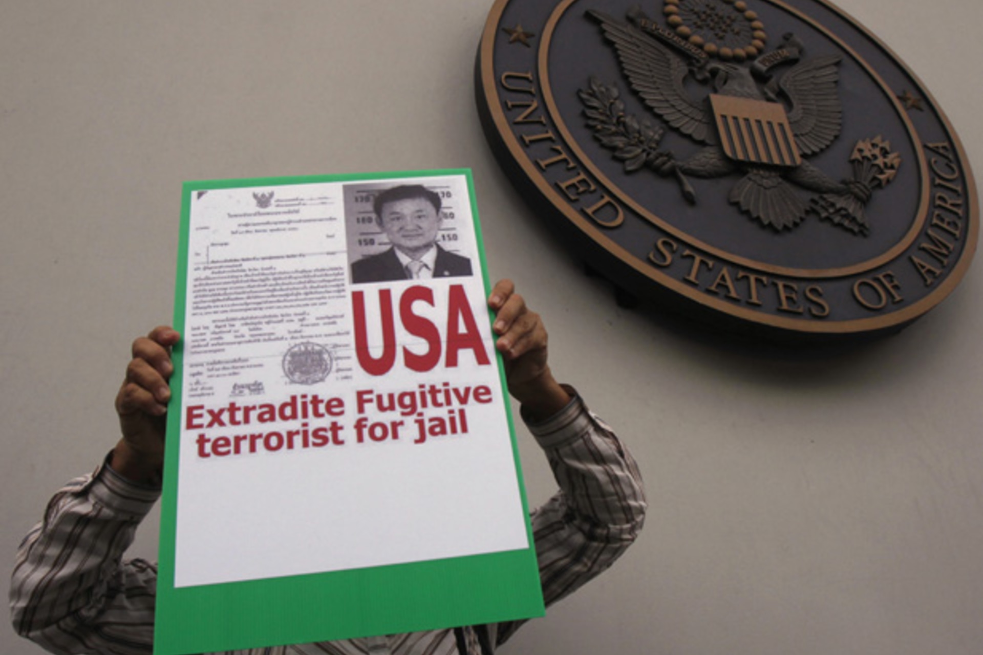 <p>A member of Nation Associate Anti-Corruption Network (NACN) holds a placard during a rally outside the U.S. embassy in Bangkok August 10, 2012.</p>
