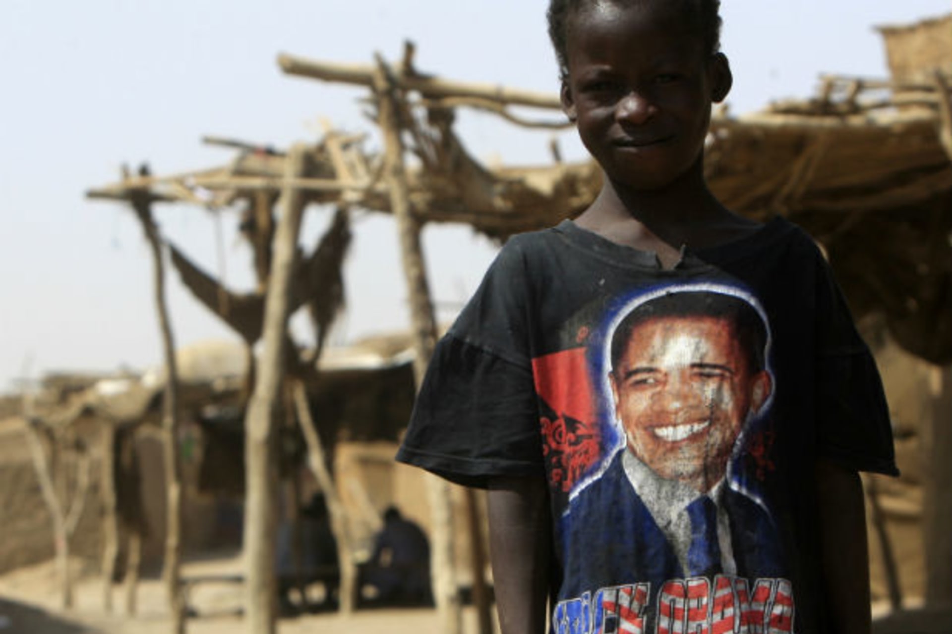 A Sudanese child from the south, wearing a t-shirt with the picture of U.S. President Barack Obama, stands near a shelter at Mandela camp, in the outskirts of Khartoum, July 4, 2011.