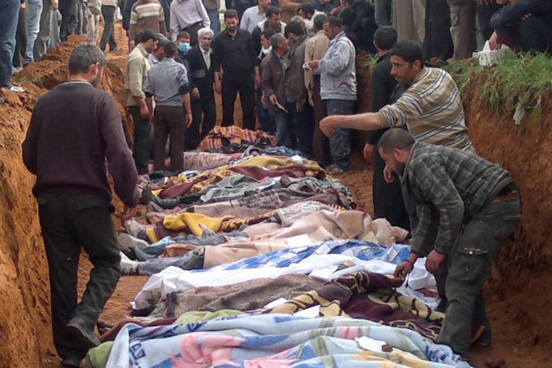 People carry the body of men, whom activists say were killed by the Syrian government army, in Taftanaz village, east of Idlib city on April 5, 2012 (Courtesy Reuters).