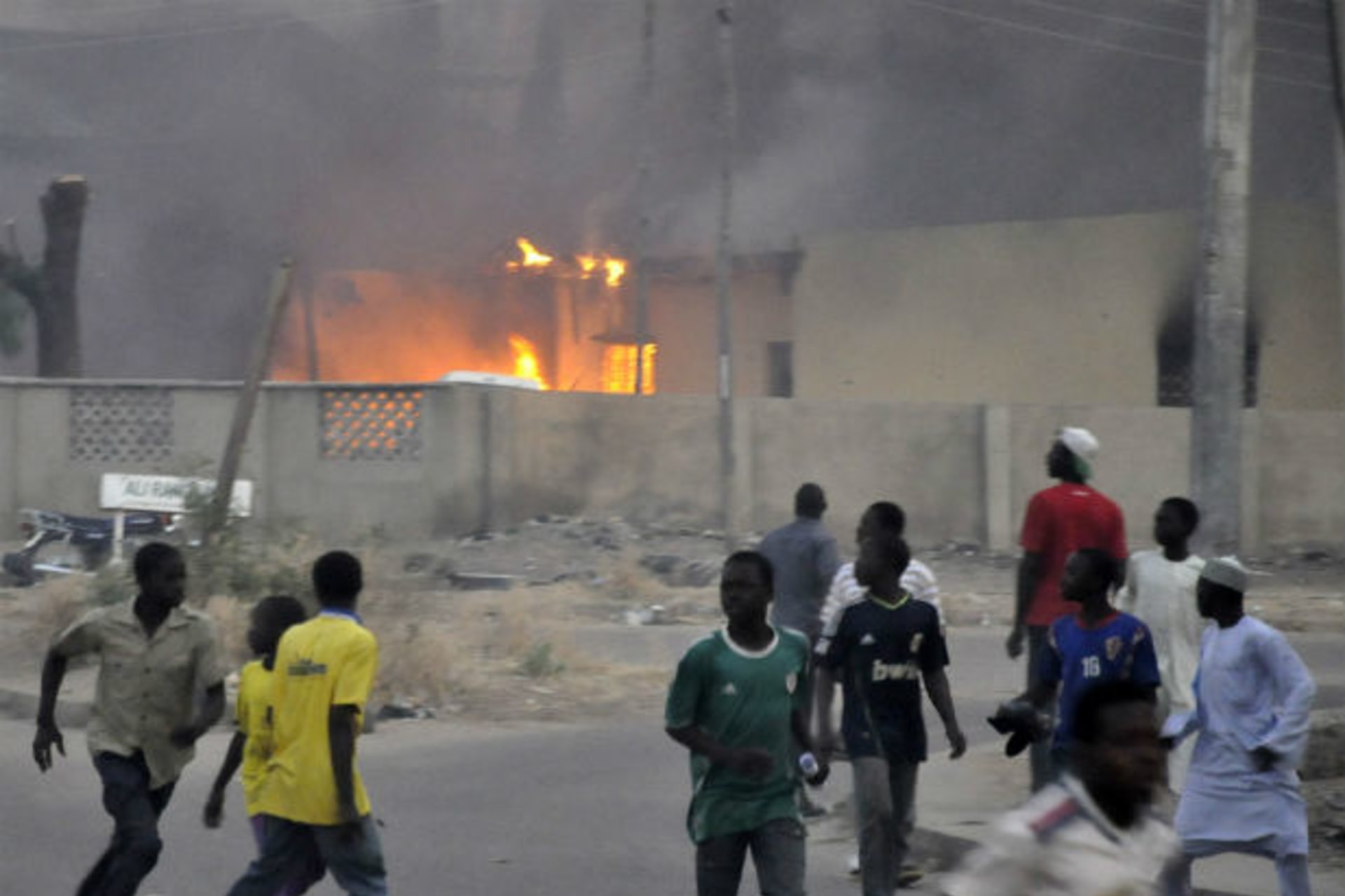 Smoke rises from the police headquarters as people run for safety after Boko Haram bomb blasts in Nigeria's northern city of Kano January 20, 2012.