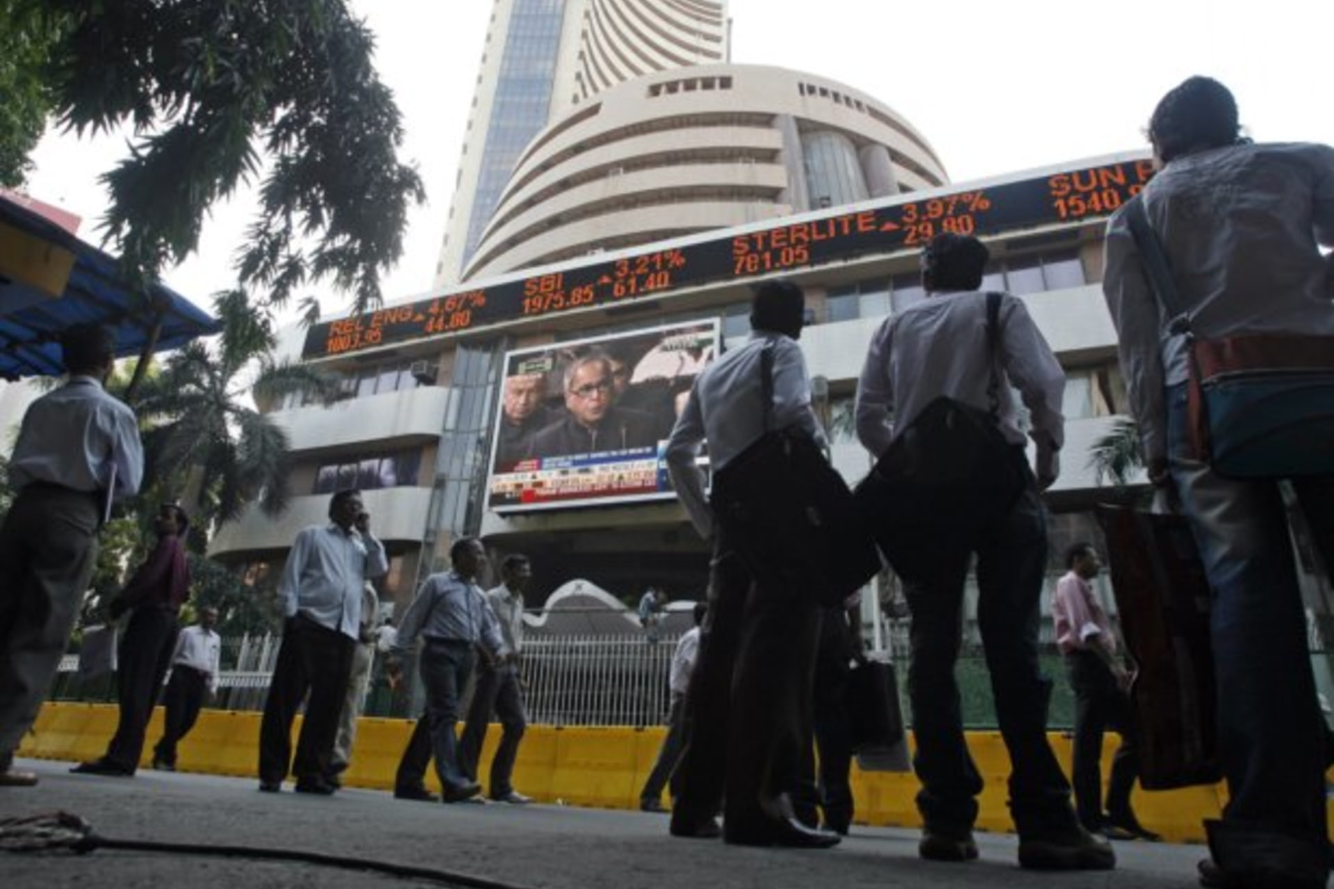 People look at a large screen displaying India's Finance Minister Mukherjee announcing the federal budget on the facade of BSE building in Mumbai (Arko Datta / Courtesy Reuters).