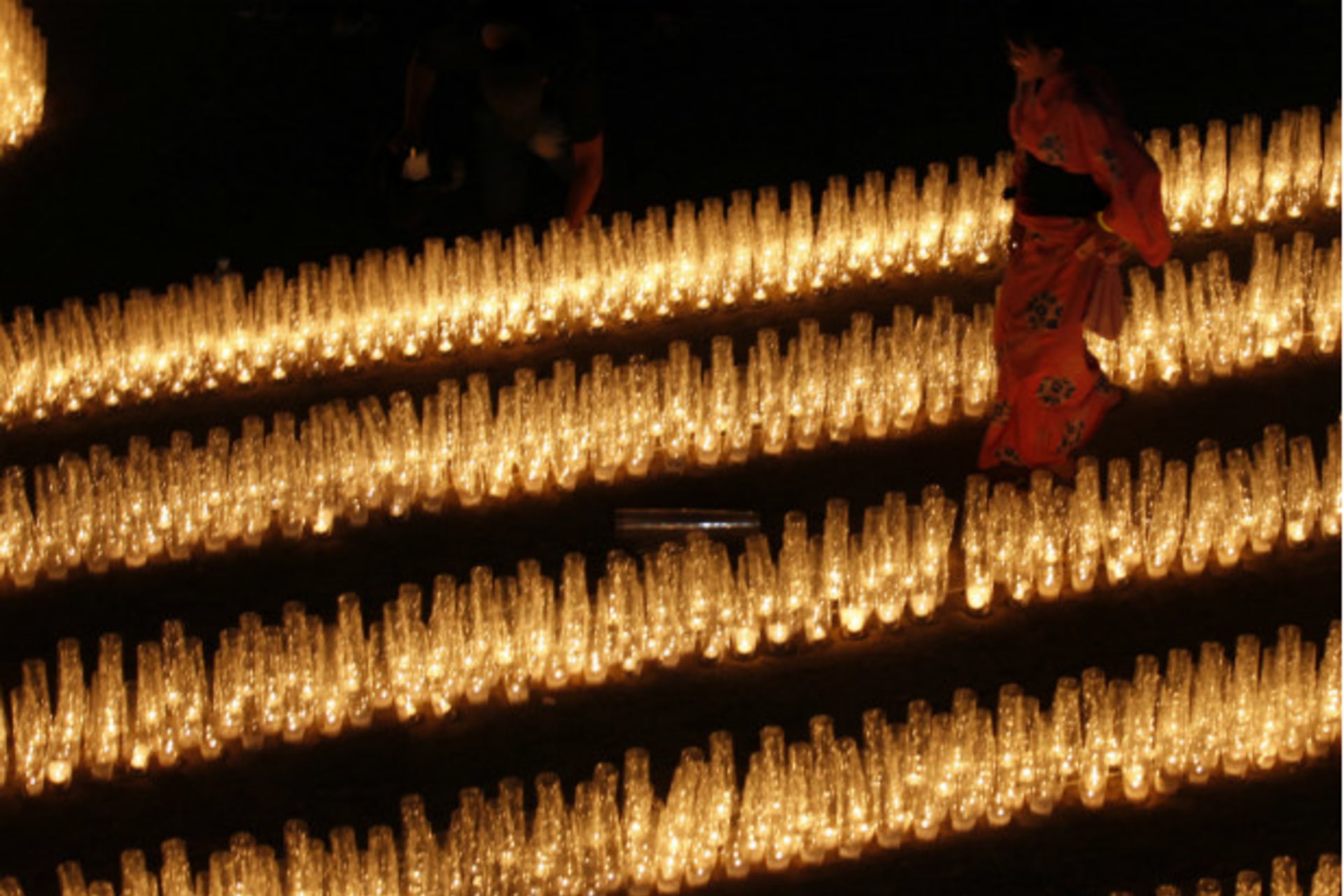 <p>A girl walks through rows of candles at a September 2011 event in Kesennuma, Japan, to commemorate those who died in the earthquake and tsunami that struck Japan on March 11, 2011. (Kim Kyung Hoon/courtesy Reuters)</p>
