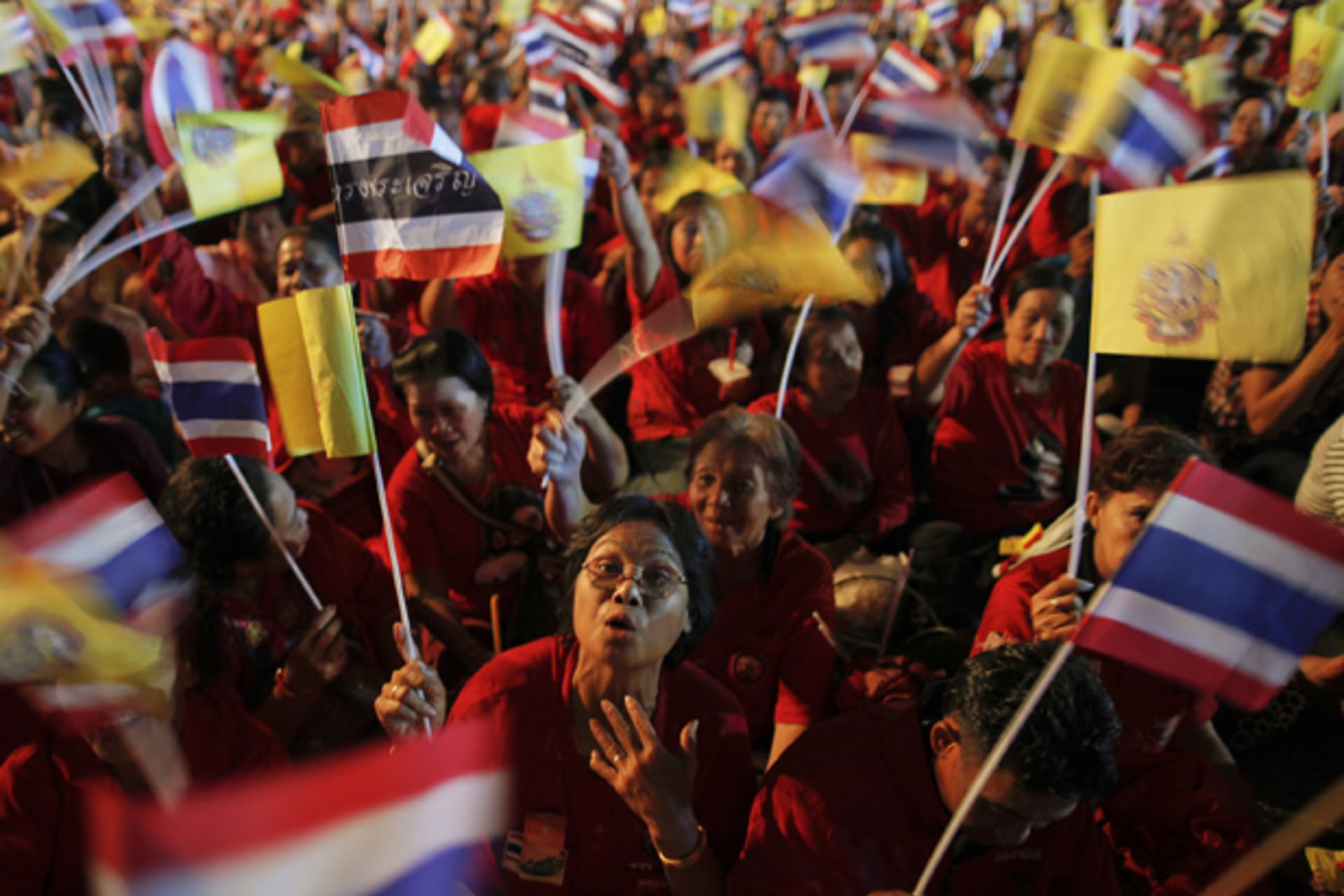 <p>Red shirt supporters wave flags as thousands of people gather outside the Grand Palace to celebrate the birthday of Thailand’s King Bhumibol Adulyadej in Bangkok.</p>
