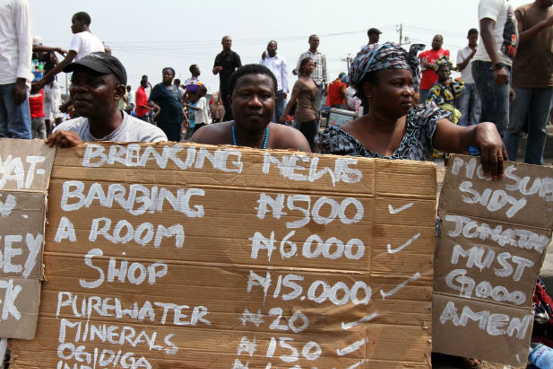 Protesters sit with signs showing prices of commodities on the fourth day of a nationwide strike against the removal of the petrol subsidy in Lagos January 12, 2012.