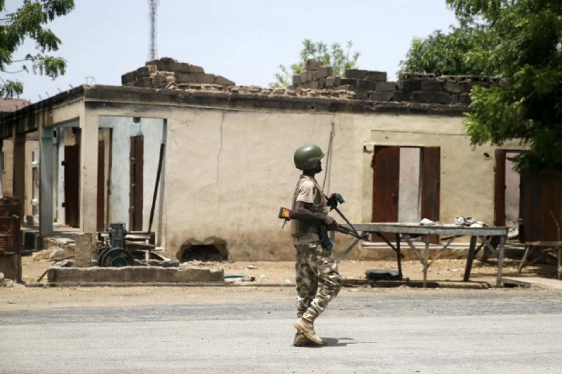 <p>A soldier walks past a burnt building in Michika town, after the Nigerian military recaptured it from Boko Haram, in Adamawa state May 10, 2015. (Akintunde Akinleye/Reuters)</p>
