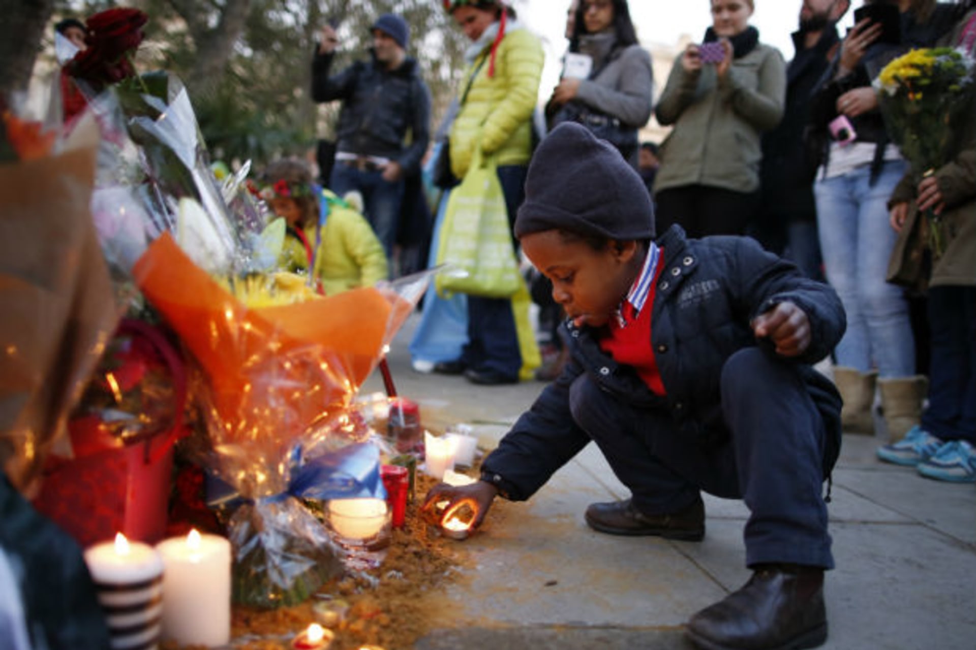 Wenceslous Nicholas, age four, lights a candle in front of the statue of former South African President Nelson Mandela in Parliament Square in central London December 8, 2013.