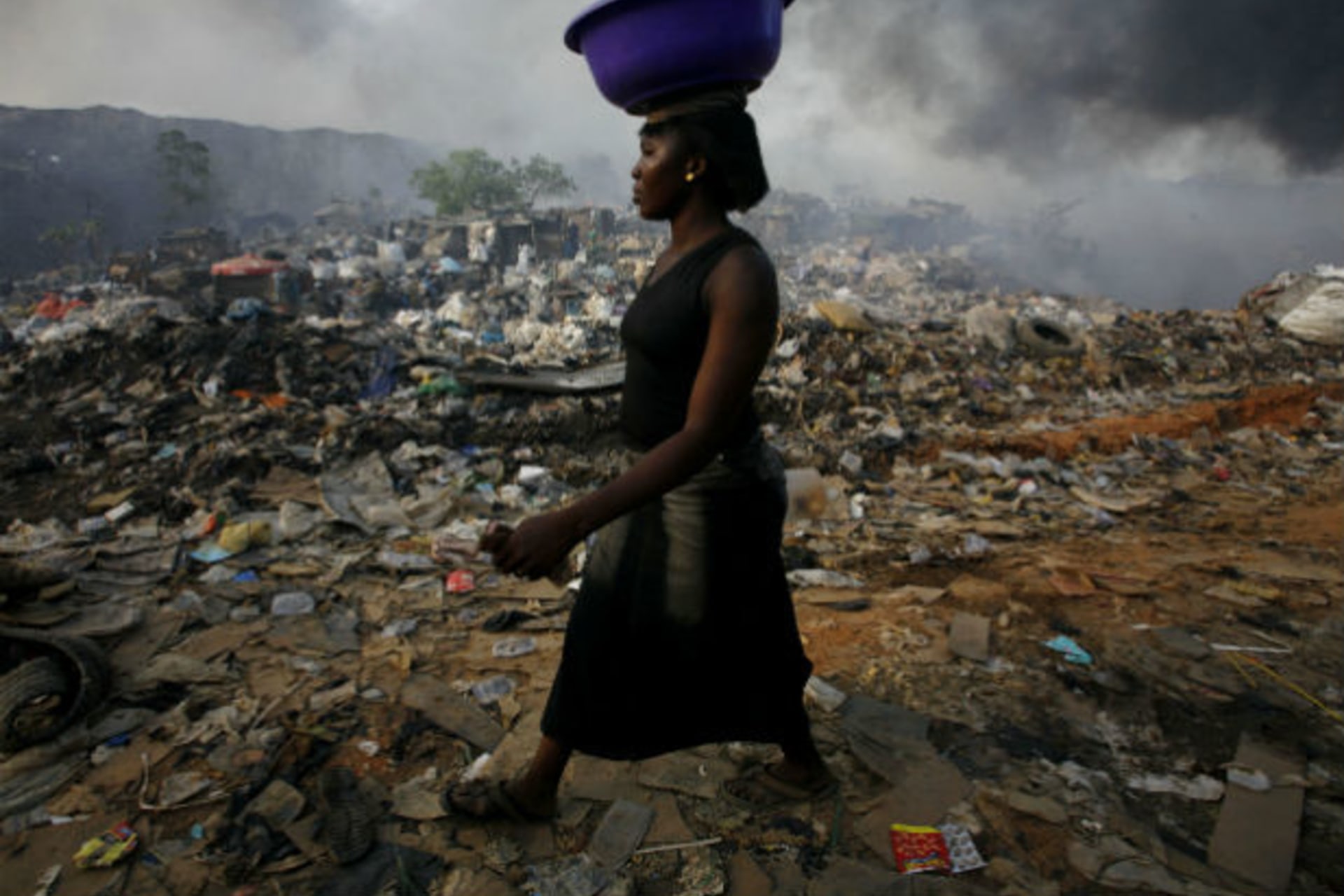 A woman walks through Olusosun rubbish dump in Nigeria's commercial capital Lagos, April 18, 2007.