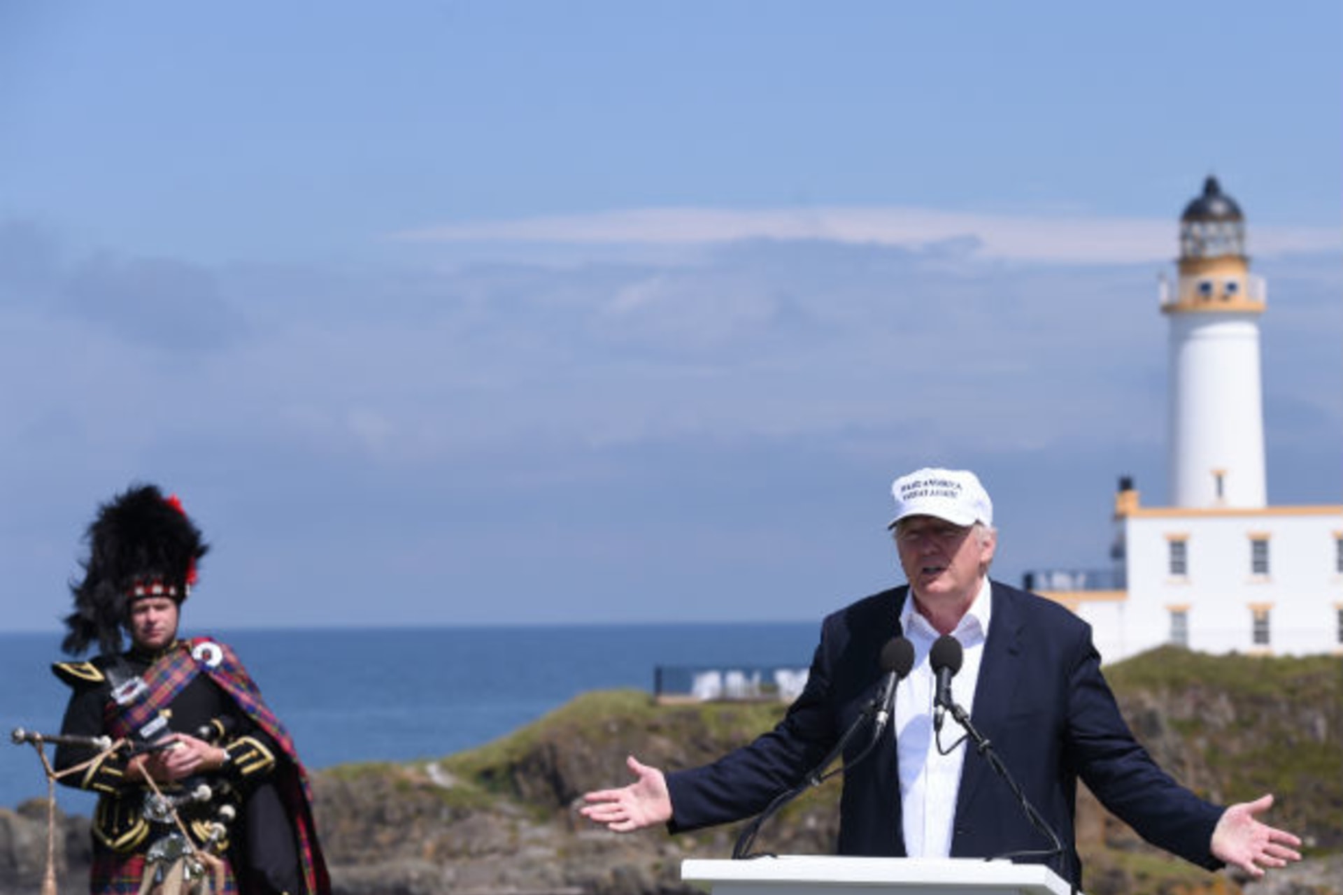 <p>Presumptive Republican presidential candidate Donald Trump speaks during a news conference, as he is watched by a piper in front of the lighthouse, at his Turnberry golf course in Scotland on June 24, 2016.</p>
