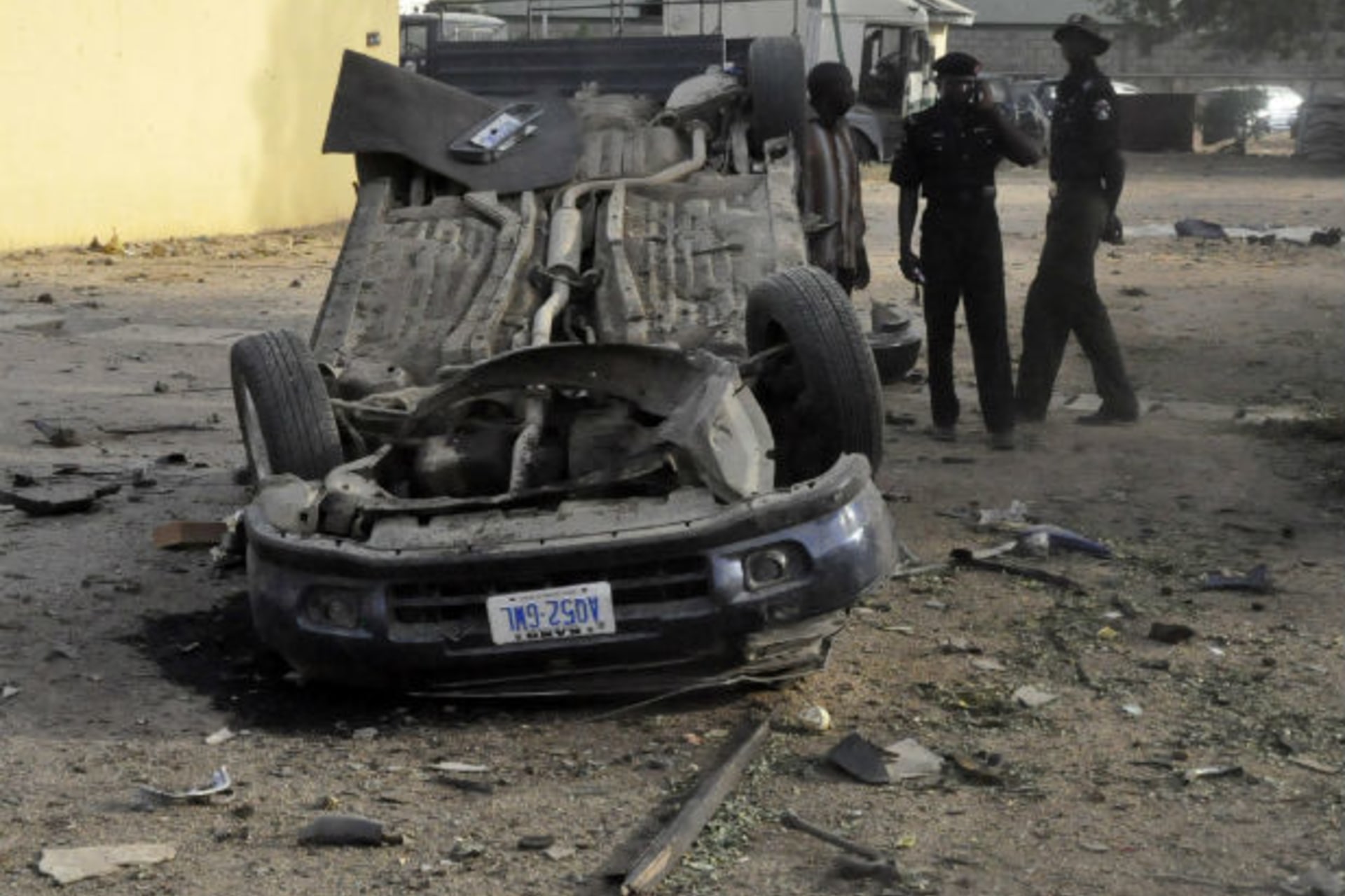 Policemen inspect a bomb site at the police headquarters in Nigeria's northern city of Kano January 22, 2012, after a bomb attack on Friday.