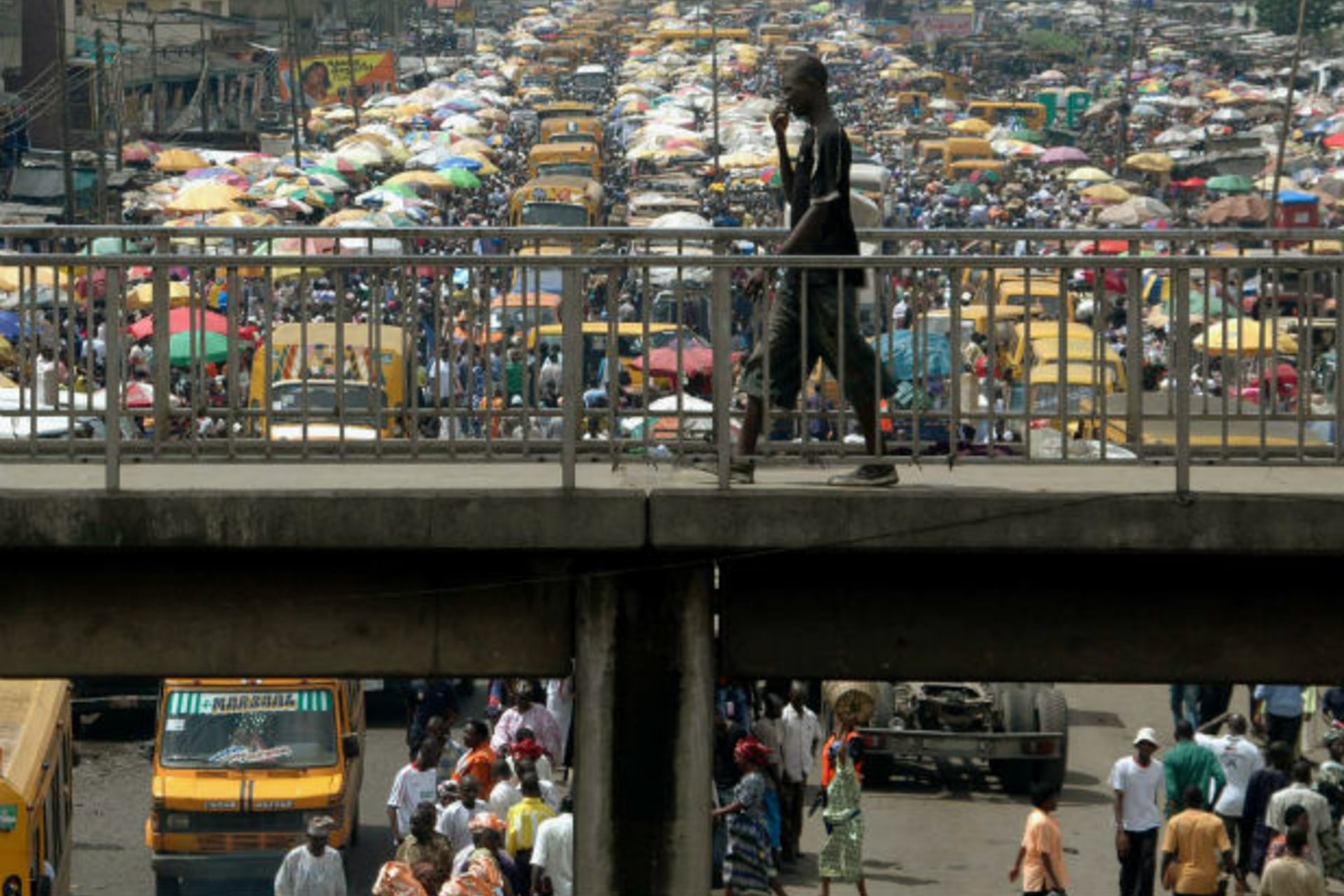 A man walks on a pedestrian bridge overlooking traffic in Lagos, Nigeria, September 18, 2006.