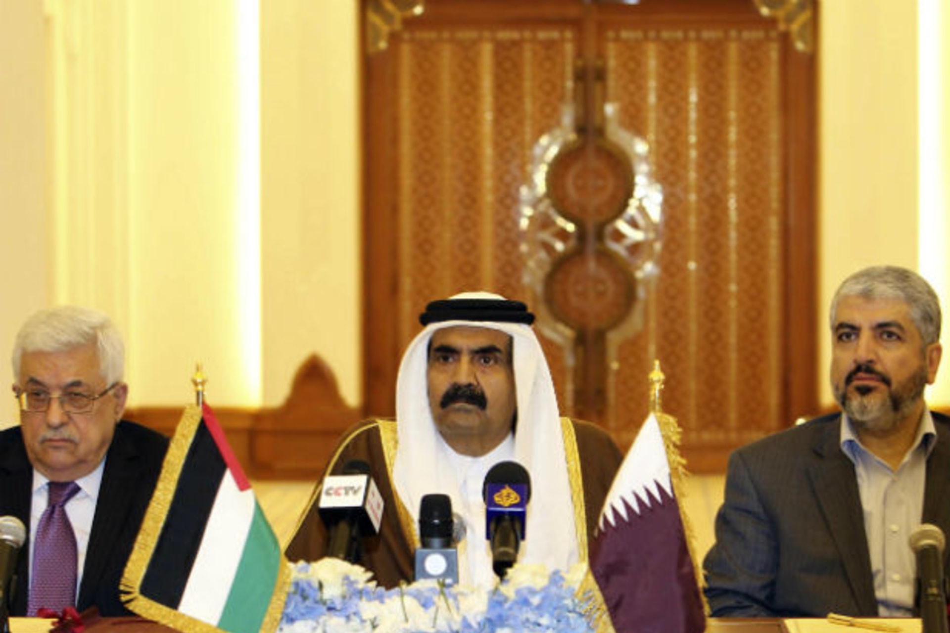 Palestinian president Mahmoud Abbas and Hamas leader Khaled Meshaal sit on either side of Qatar's emir sheikh Hamad bin Khalifa al-Thani during a meeting to sign an agreement in Doha on February 6, 2012 (Courtesy Reuters).