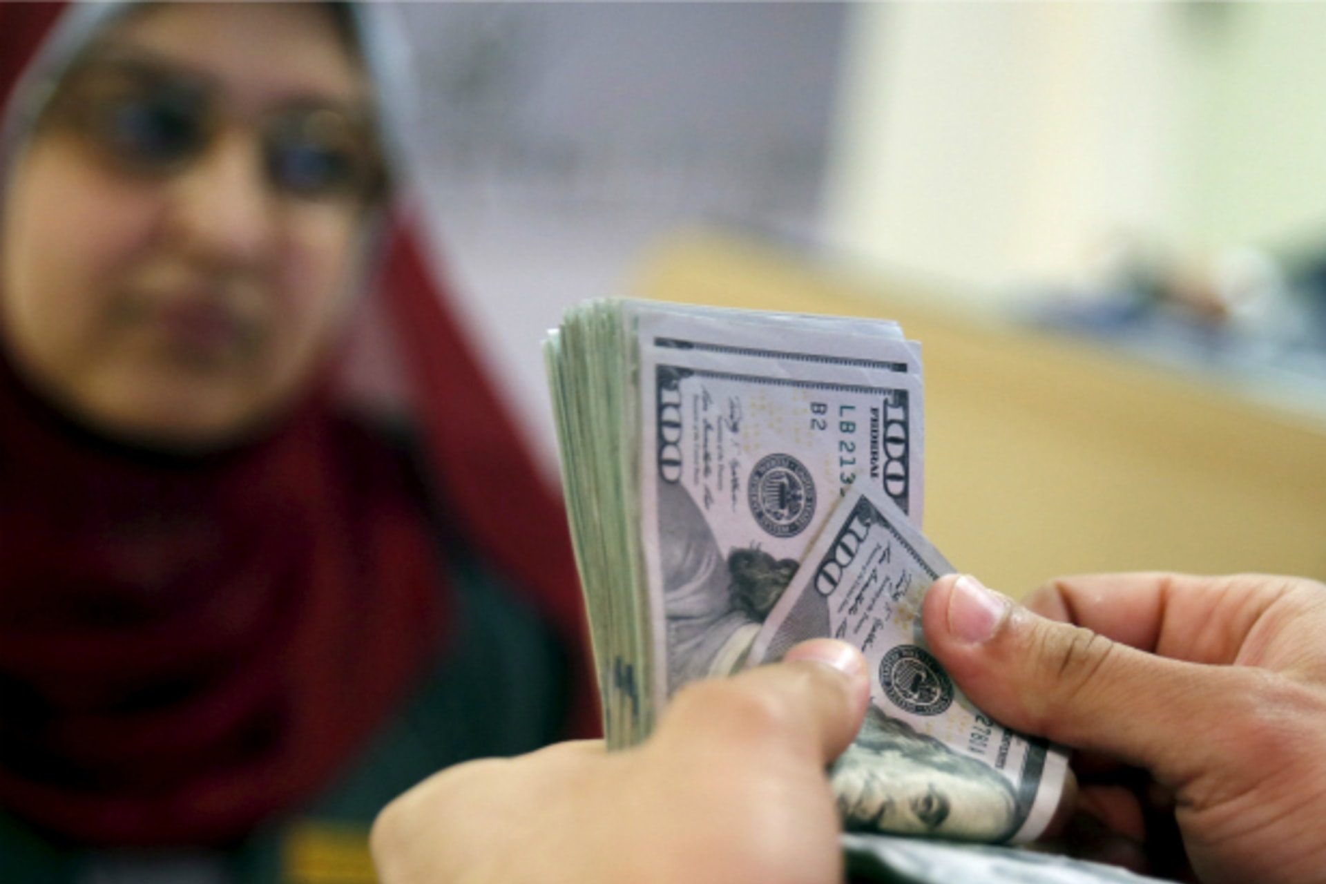 <p>A customer counts his U.S. dollar money in a bank in Cairo, Egypt (Amr Abdallah Dalsh/Reuters).</p>
