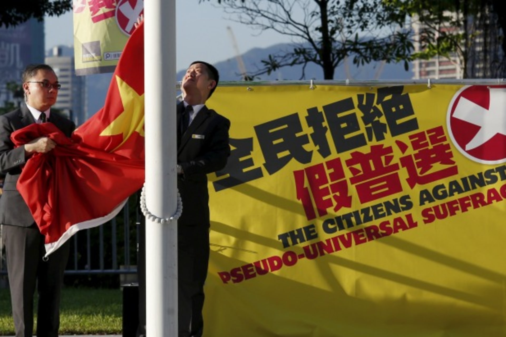 <p>Flagbearers lower a Chinese national flag beside a banner set up by pro-democracy protesters outside Legislative Council in Ho… it braces for a fresh showdown over plans for how its next leader is elected in 2017. REUTERS/Bobby Yip TPX IMAGES OF THE DAY</p>

