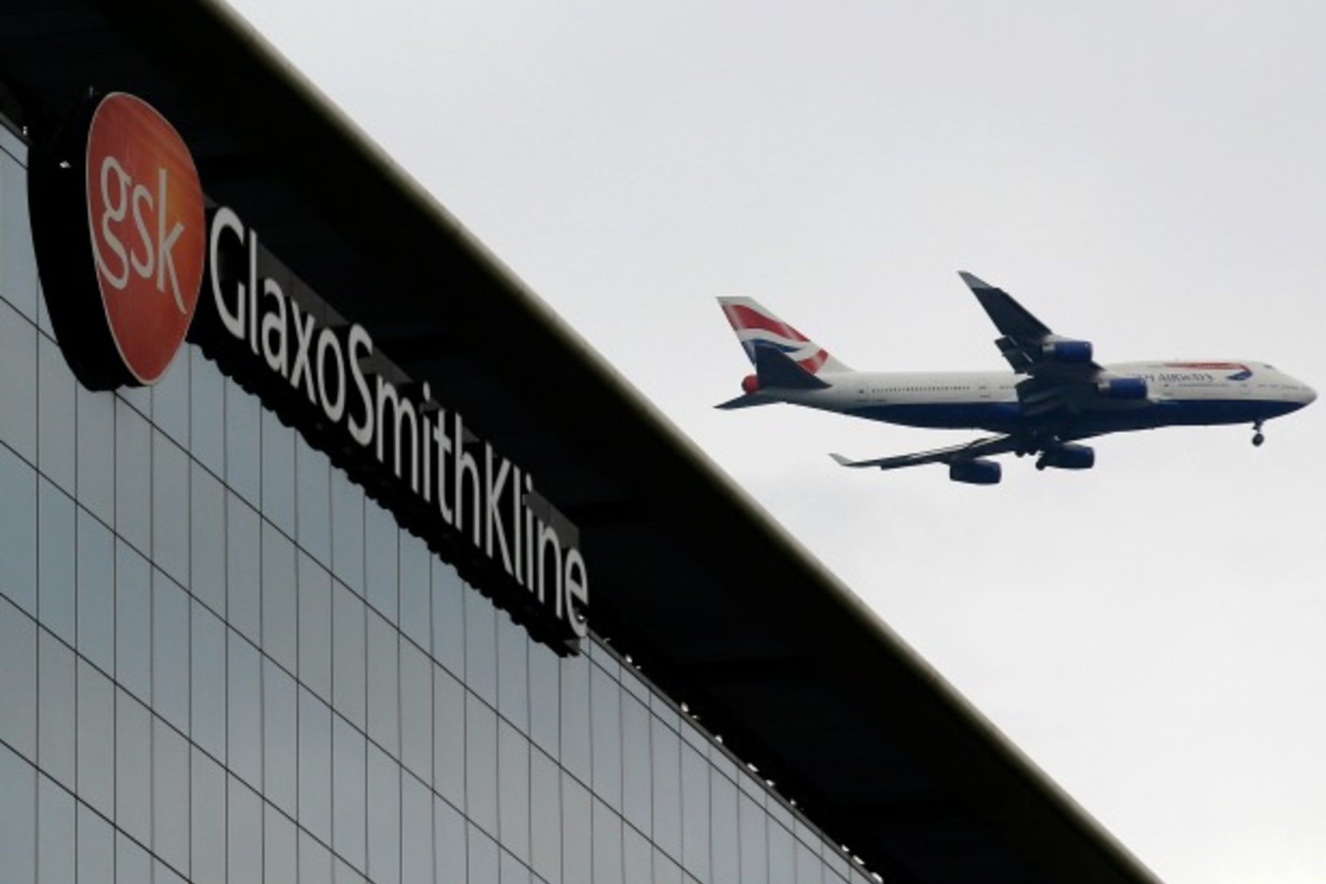 <p>A British Airways airplane flies past a signage for pharmaceutical giant GlaxoSmithKline (GSK) in London on April 22, 2014. (Luke MacGregor/Courtesy Reuters)</p>