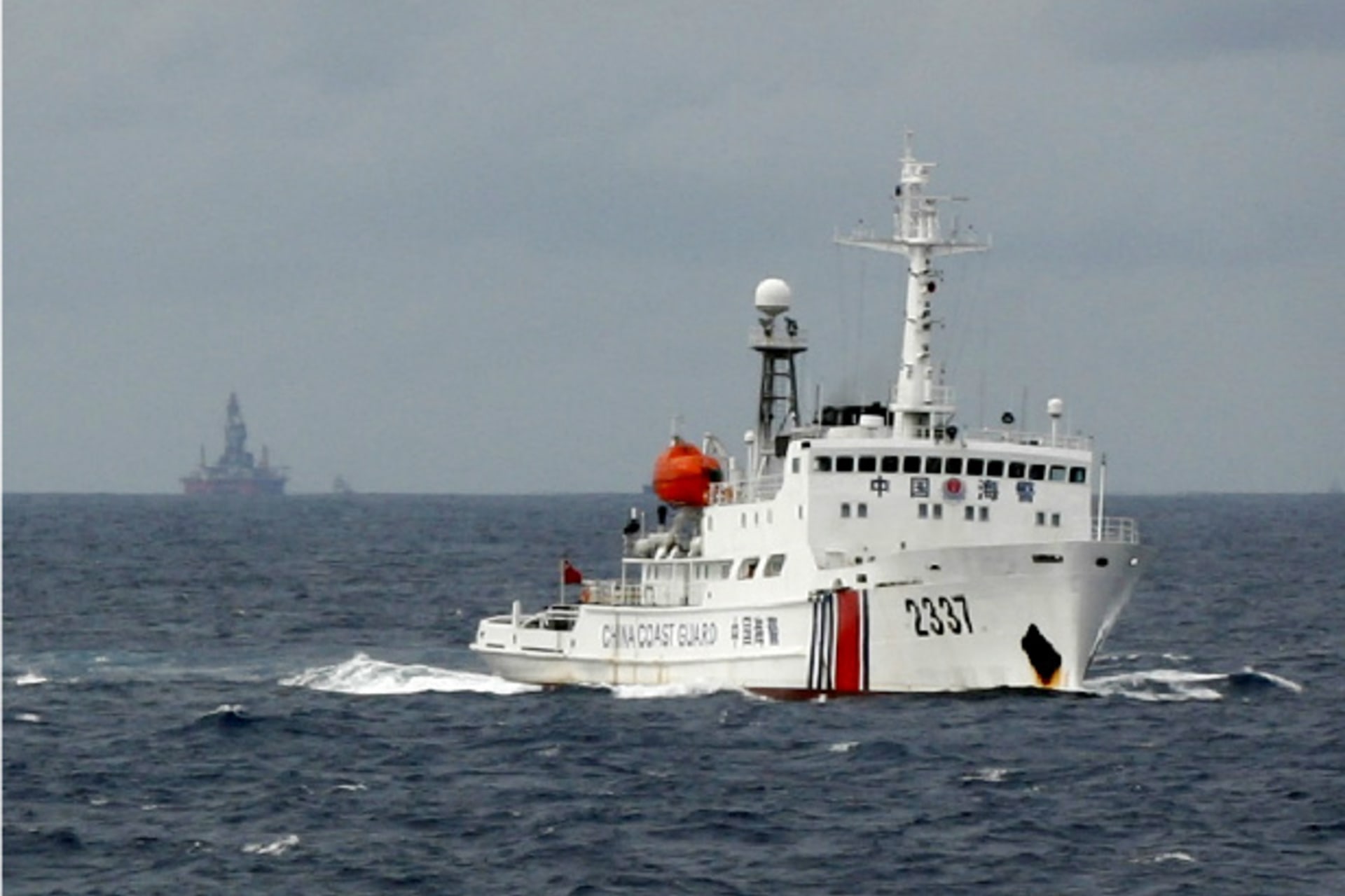 <p>A Chinese Coast Guard vessel (R) passes near the Chinese oil rig, Haiyang Shi You 981 (L), in the South China Sea, about 210 km (130 miles) from the coast of Vietnam on June 13, 2014 (Courtesy: Reuters).</p>
