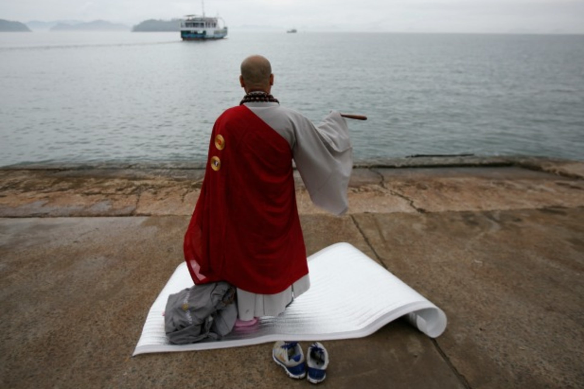 <p>A Buddhist monk prays for the missing passengers on the South Korean ferry, Sewol on April 18, 2014. The ferry had been en rou…a holiday island off South Korea’s southern coast, when it sent a distress signal on April16 (Issei Kato/Courtesy: Reuters).</p>
