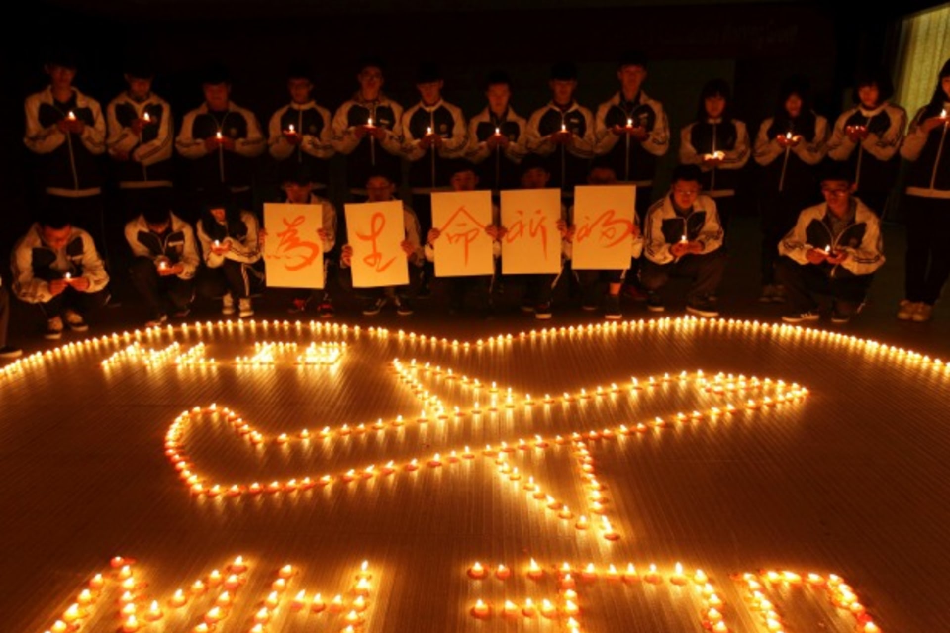 <p>International school students light candles to pray for passengers aboard Malaysia Airlines flight MH370, in Zhuji, Zhejiang province, on March 10, 2014. (Stringer/Courtesy Reuters)</p>
