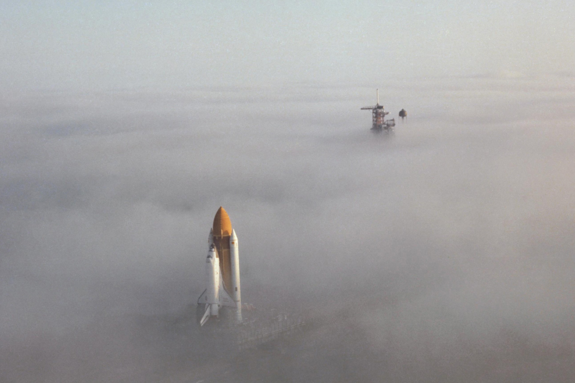 <p>The Space Shuttle Challenger moves through the fog on its way down the crawler way en route to Launch Pad 39A at Kennedy Space Center in this NASA handout photo dated November 30, 1982.</p>
