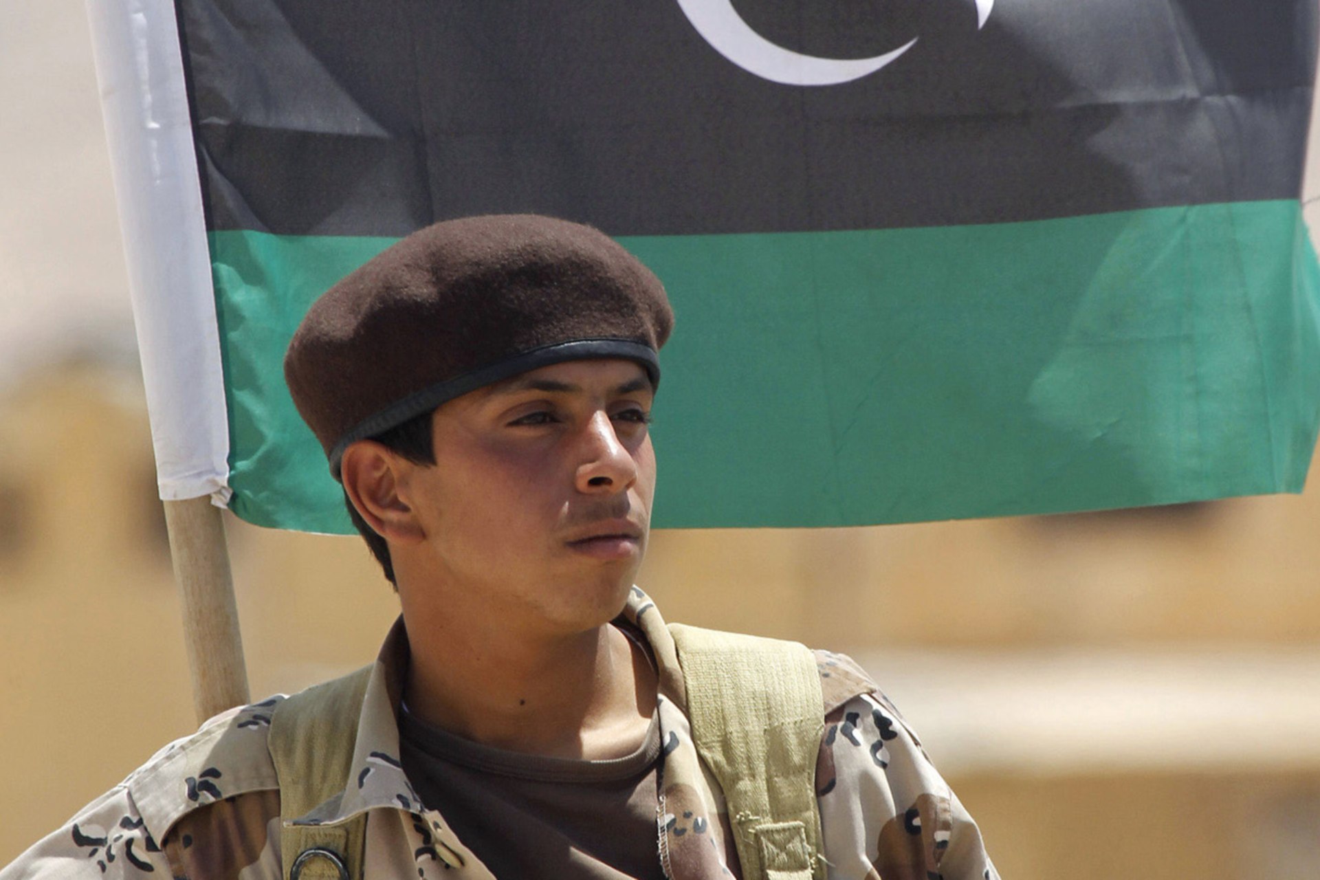 <p>A Libyan rebel fighter stands on a truck bearing the flag of the rebel army at a checkpoint near the town of Nalut, in western Libya, on July 29, 2011.</p>