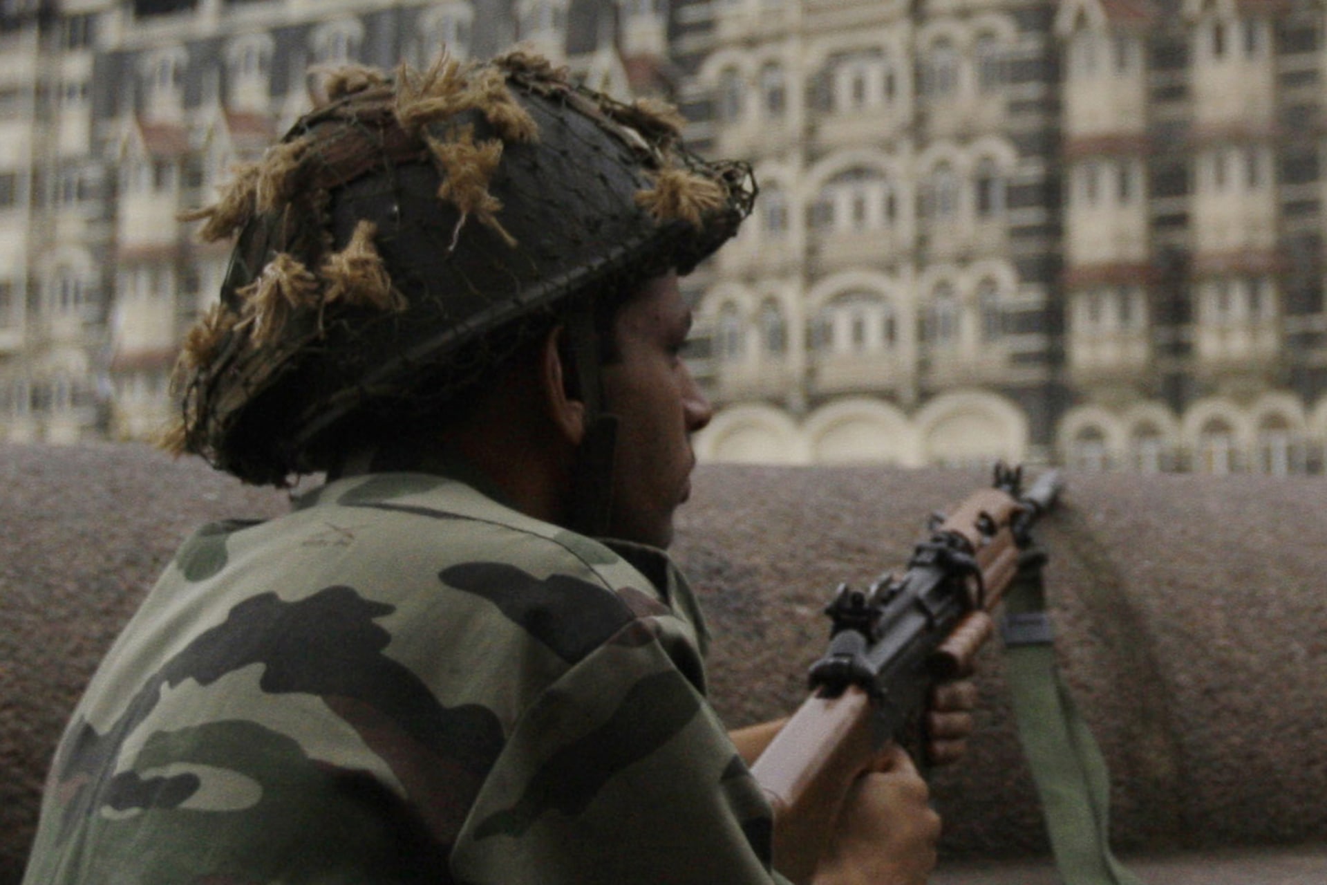 <p>The Taj Hotel burns as Indian soldiers take cover along a sea wall during gun battles between Indian troops and militants in Mumbai on November 29, 2008.</p>