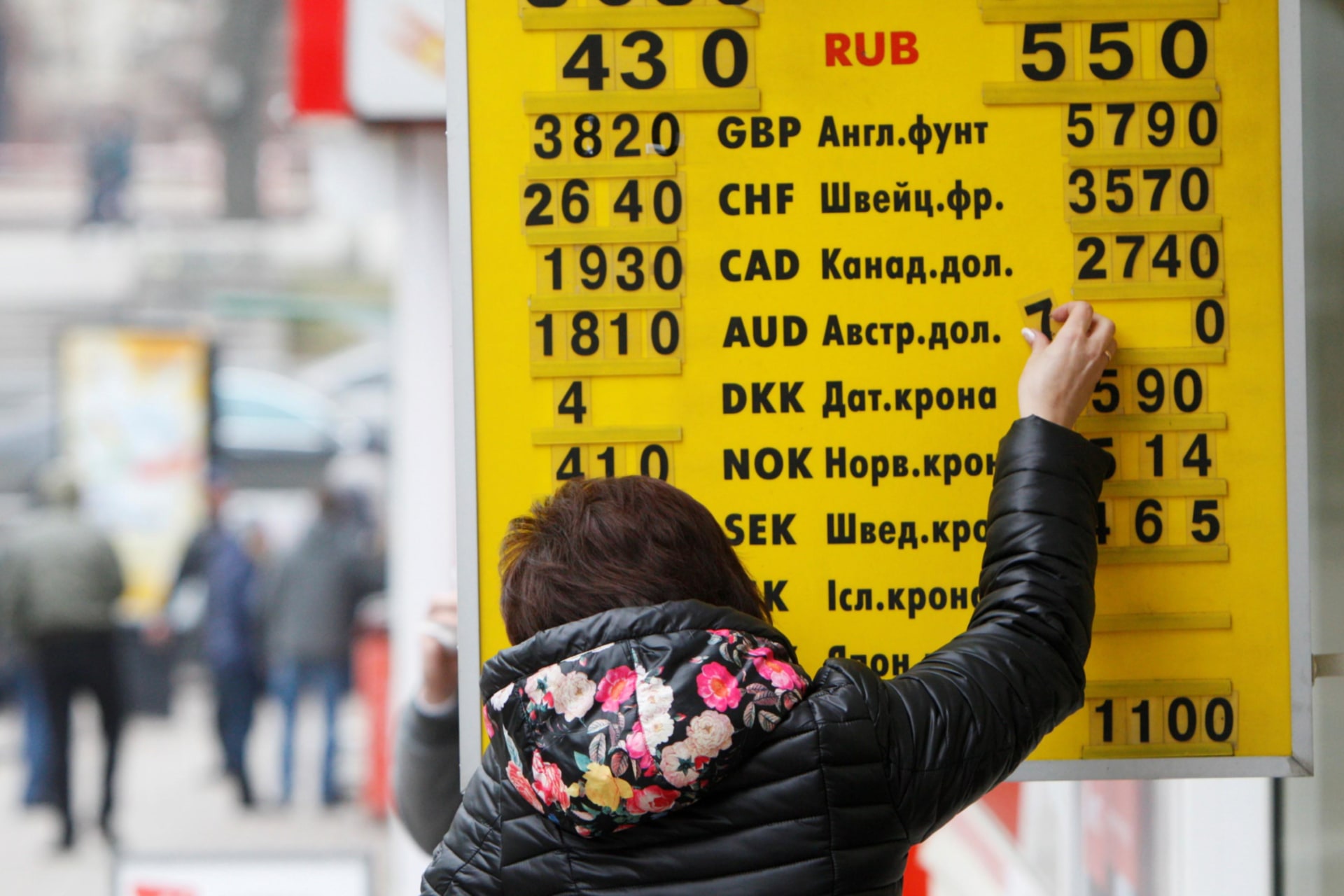 <p>A woman changes an exchange rate on a display board at a currency exchange office in Kiev on February 26, 2015.</p>
