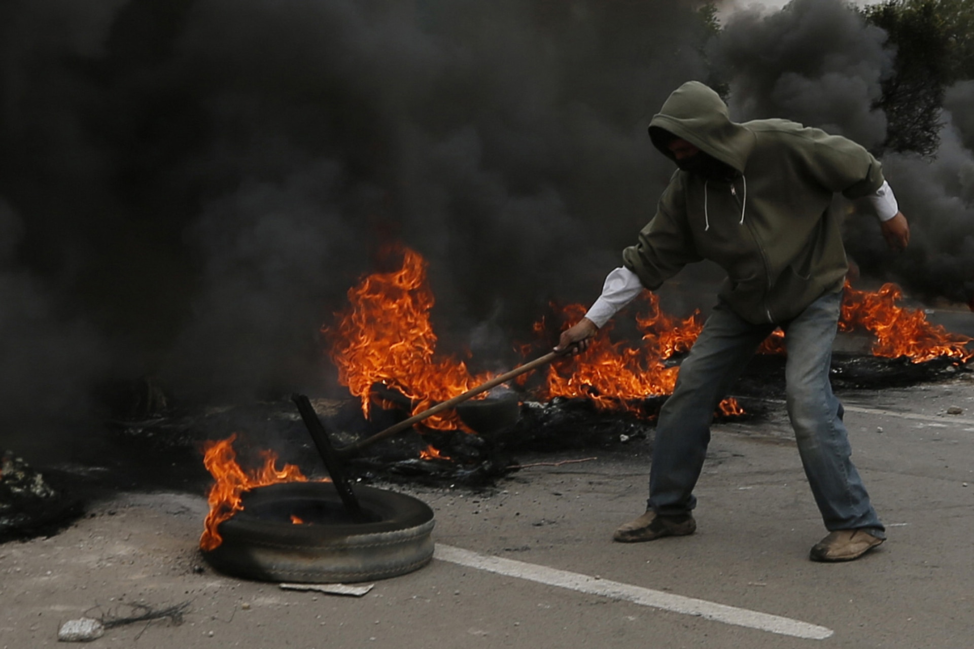 <p>A demonstrator blocks a street with burning tyres during a protest against fuel price hikes in Sanaa on July 30, 2014.</p>
