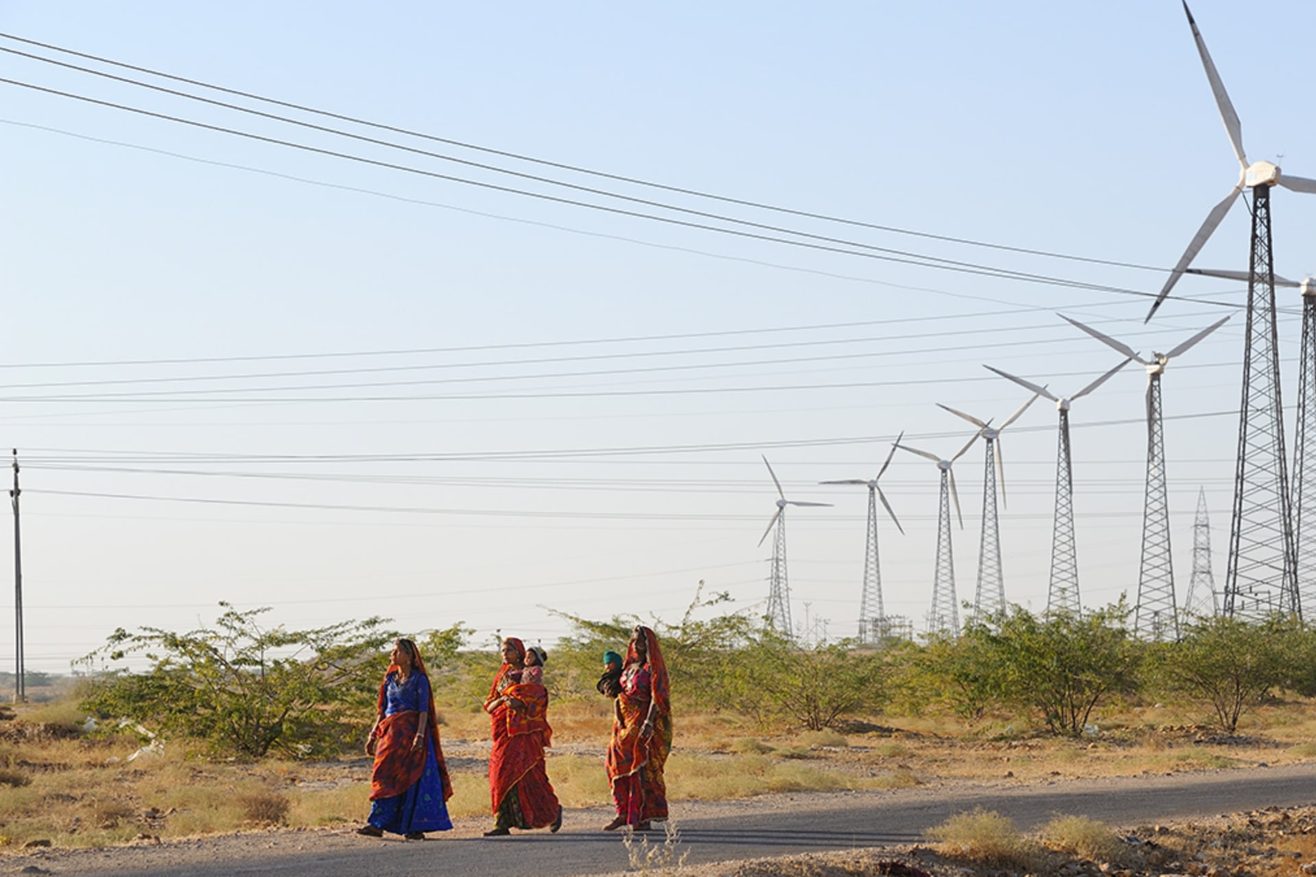 <p>Women walk among windmills in Jaisalmer, India, on March 8, 2017.</p>
