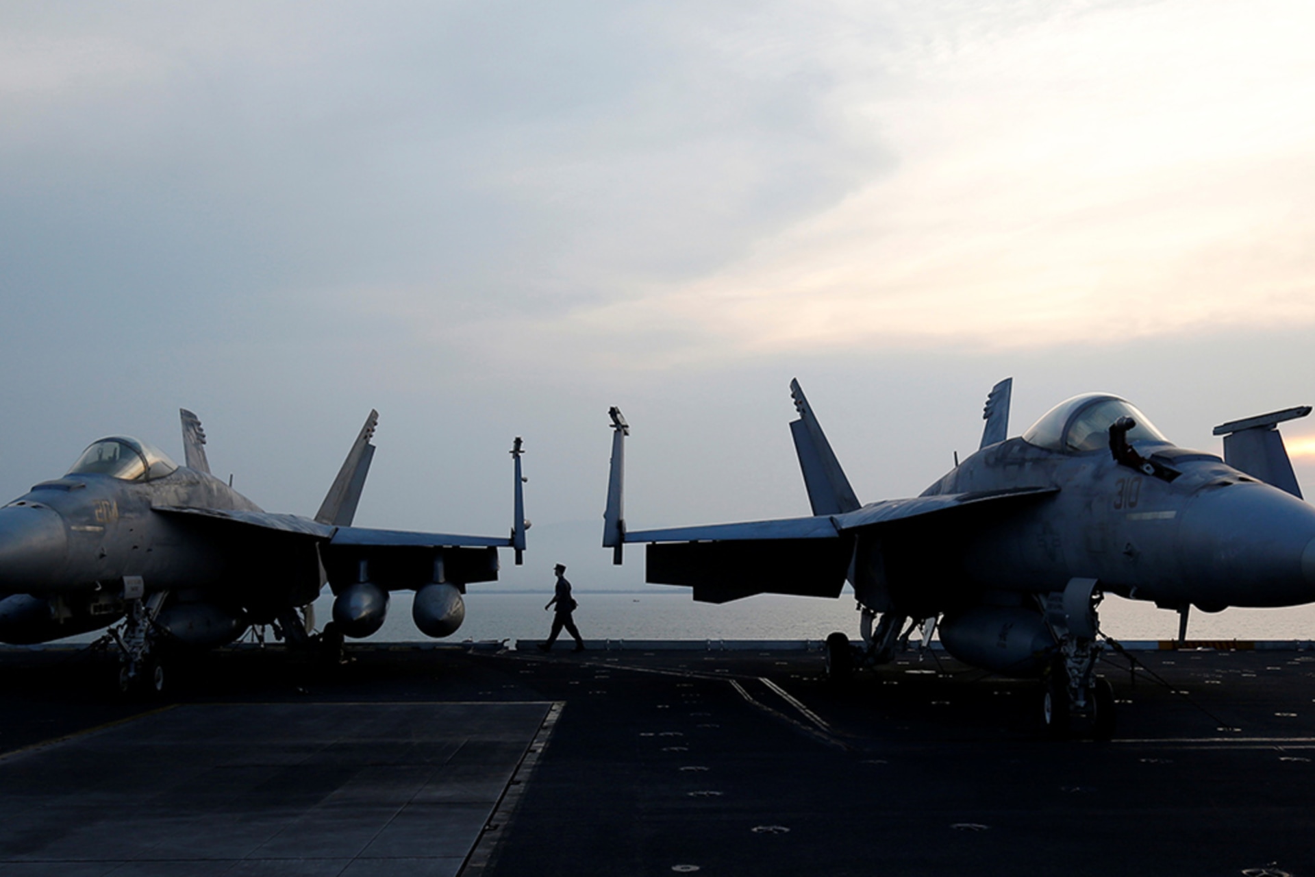 <p>A sailor walks behind aircraft on the U.S. Navy carrier USS Carl Vinson after it docked at a port in Danang, Vietnam, on March 5, 2018.</p>
